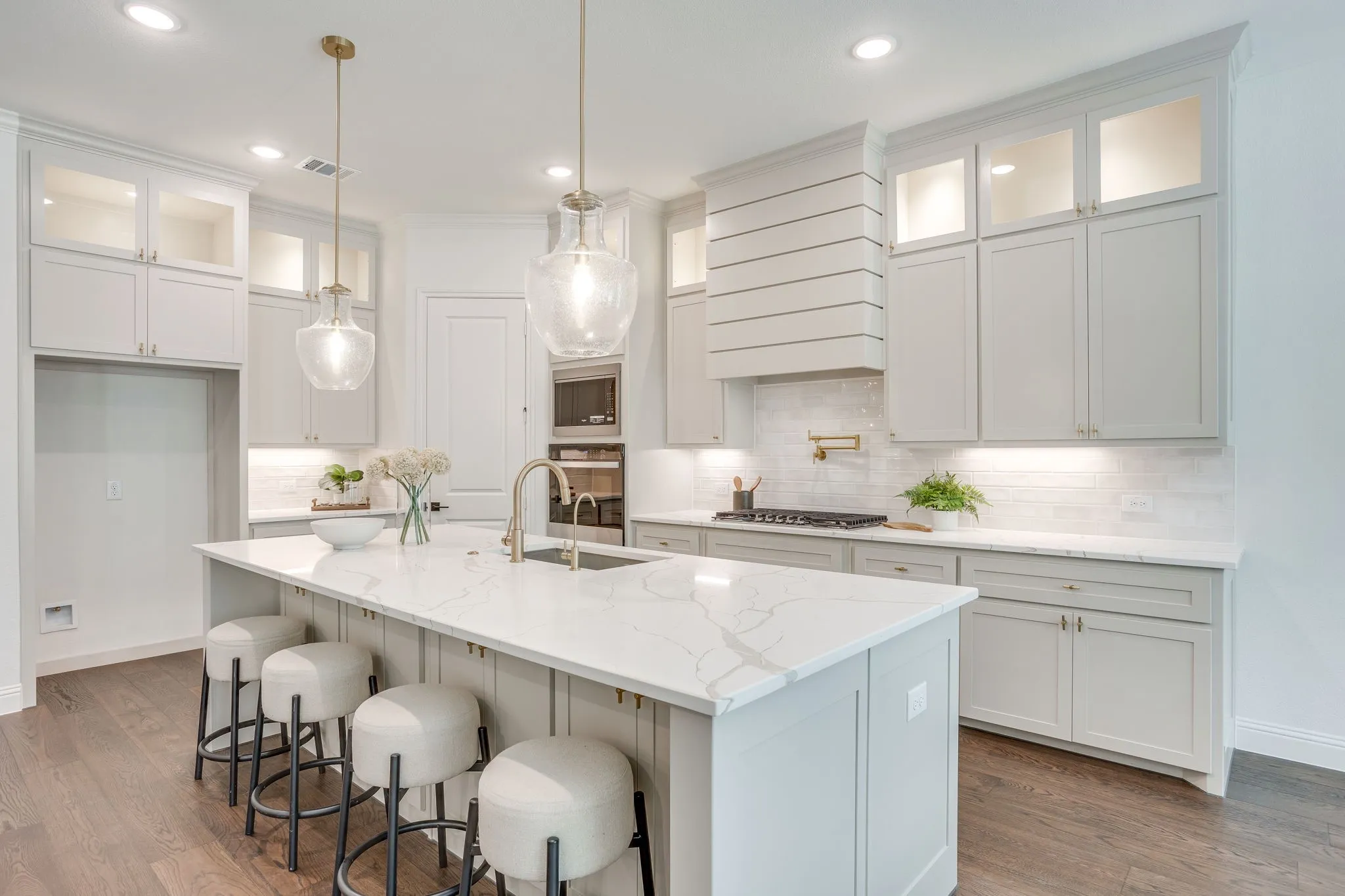 Kitchen featuring a central island with countertop, shaker-style cabinetry, wood-finish flooring, recessed lighting, and pendant light fixtures