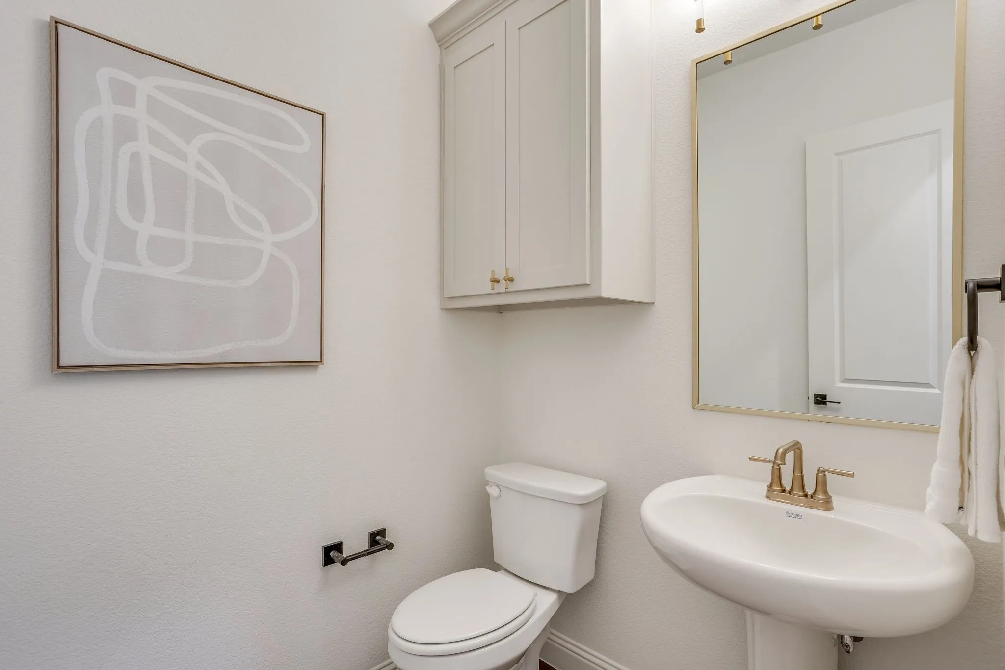 Powder bath with custom cabinetry.