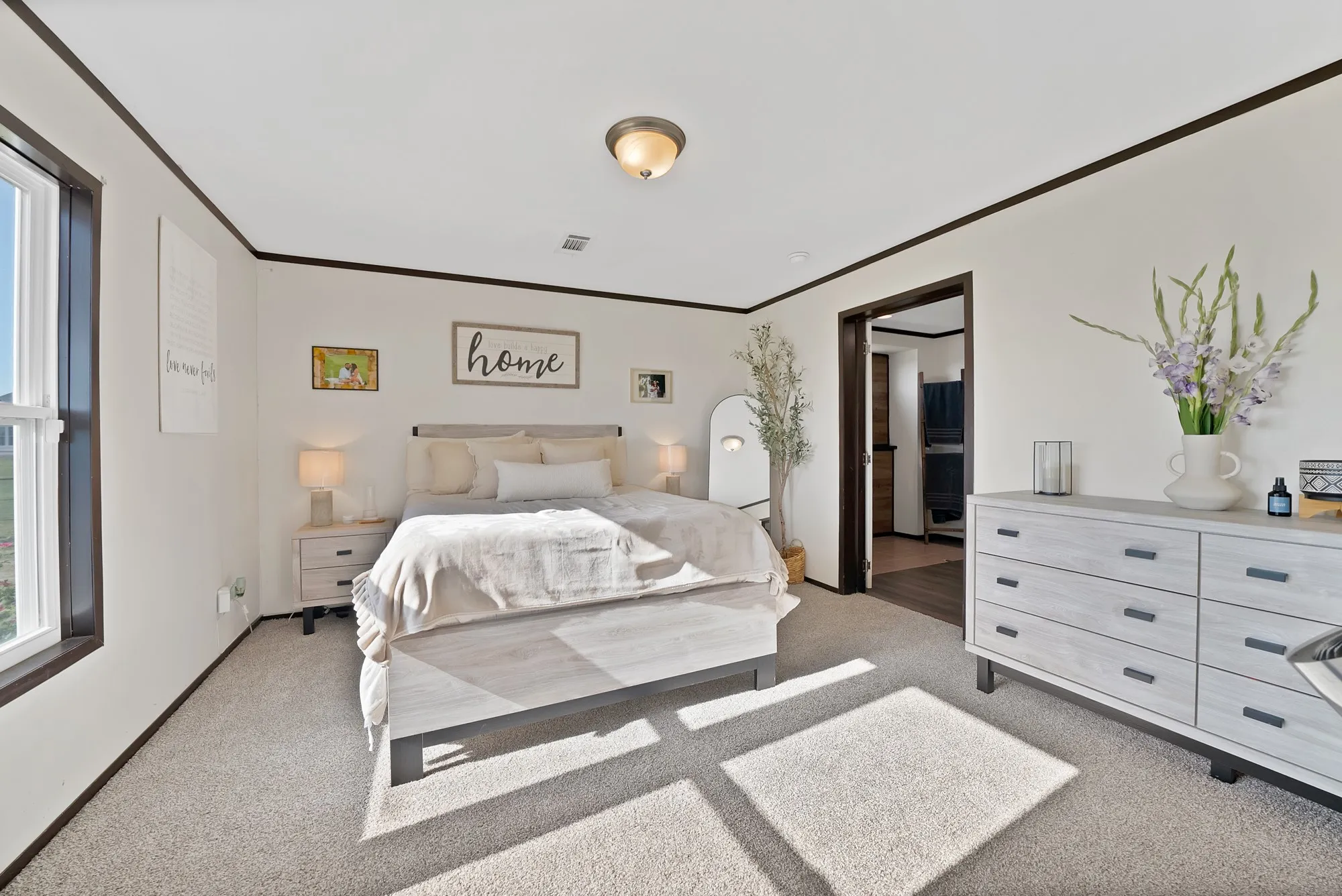 Carpeted room with a ceiling-mounted light fixture, white walls, and dark trim