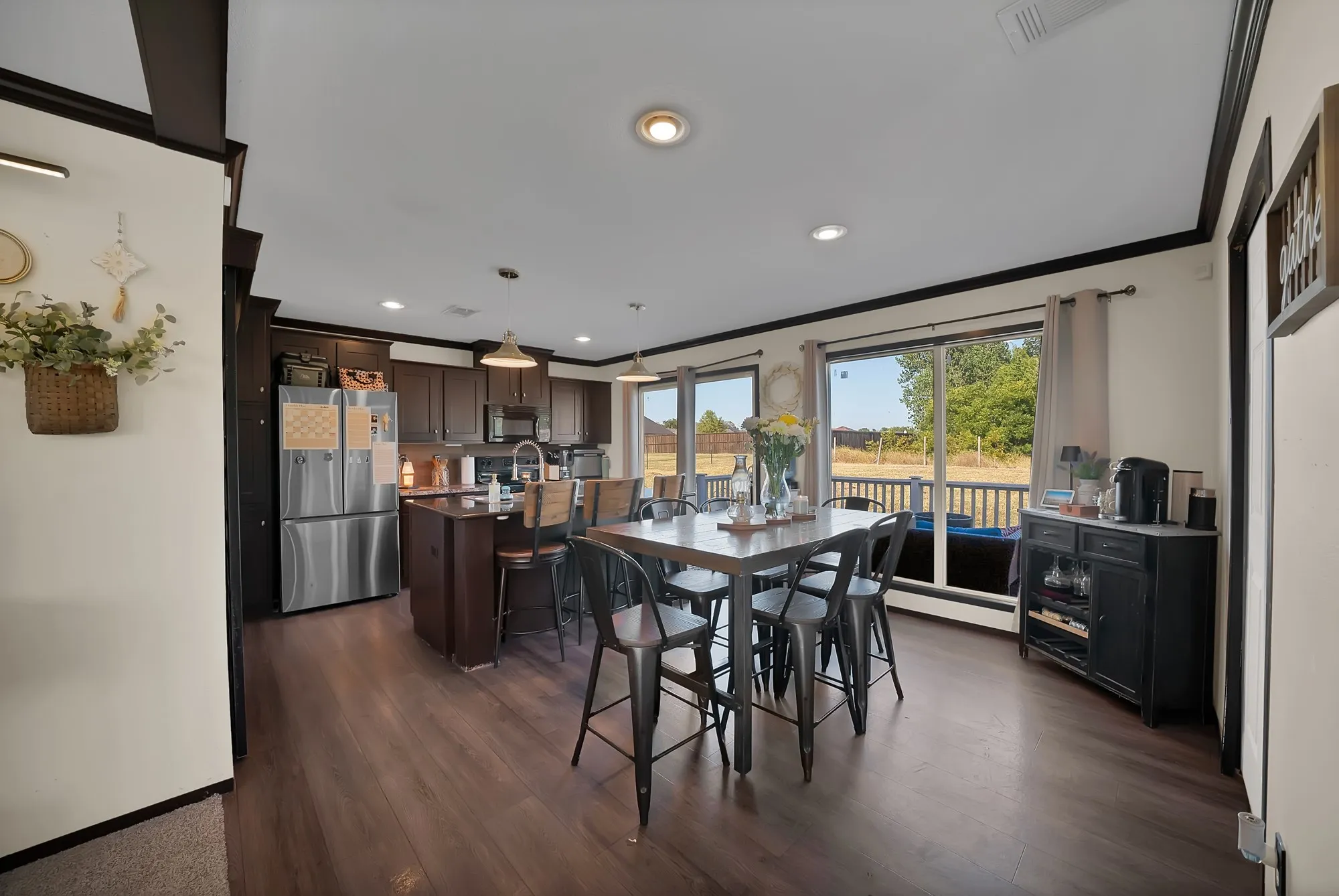 Wood-finish flooring throughout, with dark wood cabinetry and a kitchen island