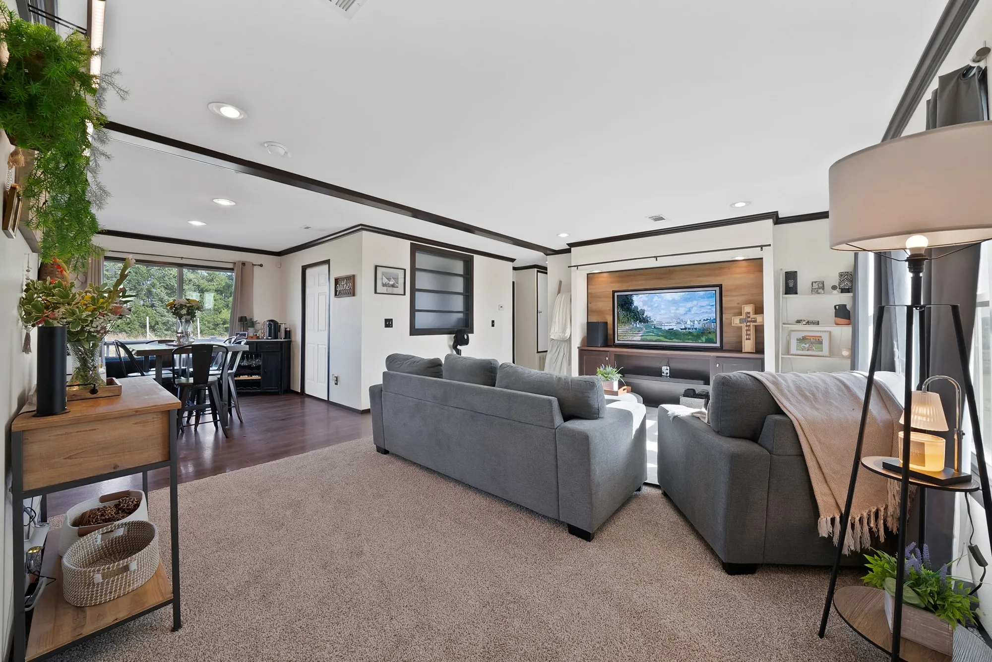 Open-concept living space featuring recessed lighting, dark wood-finish flooring, and a built-in media center with a wood accent wall