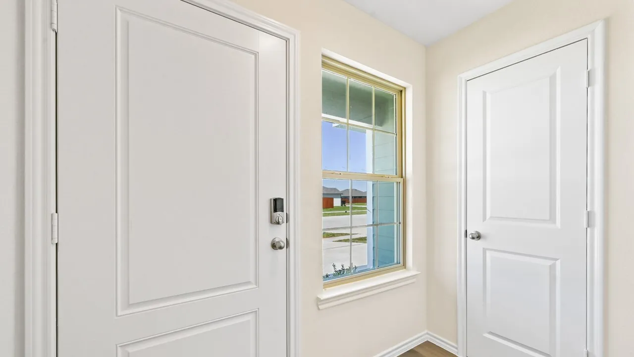 Panel interior door with smart lock, contrasting interior wall color, and wood-finish flooring