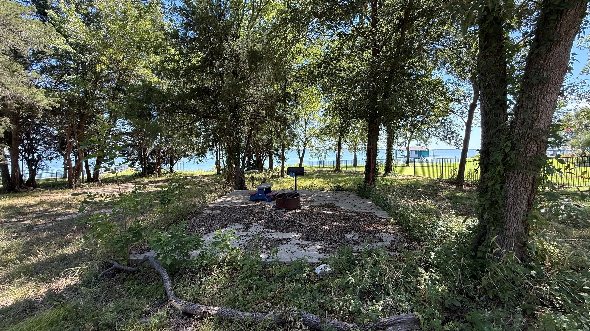 Existing outdoor gathering space beneath mature trees hints at relaxing weekends and evenings at a Richland Chambers Lake retreat.