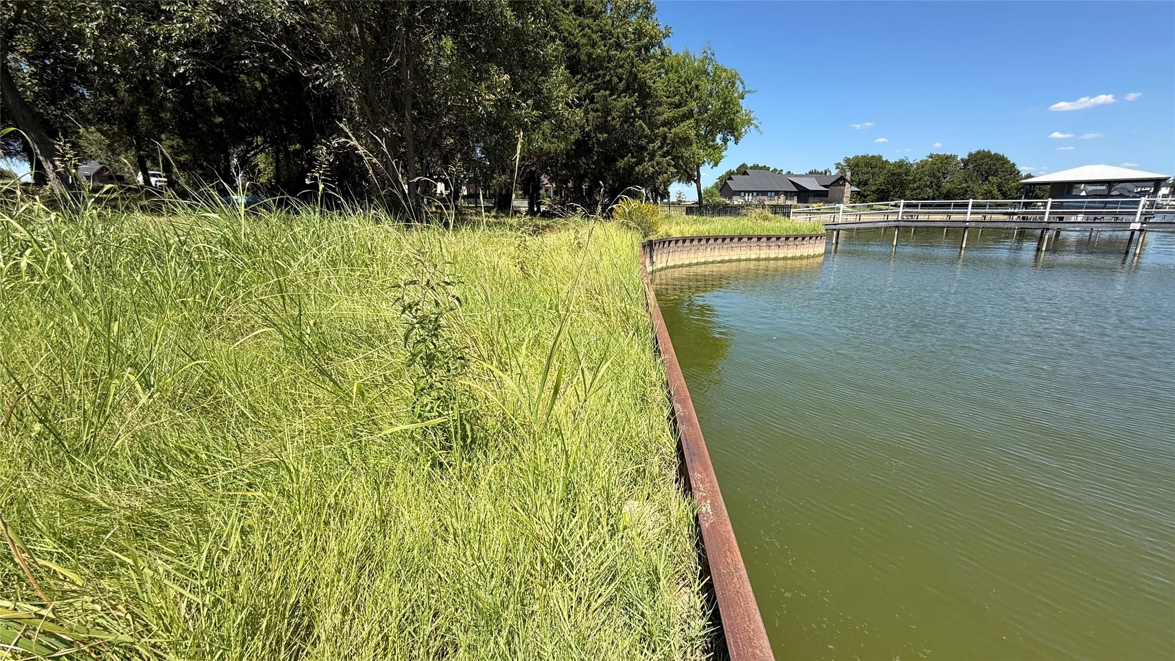 Established steel retaining wall defines the shoreline of this wooded waterfront lot on Richland Chambers Lake in Navarro County.