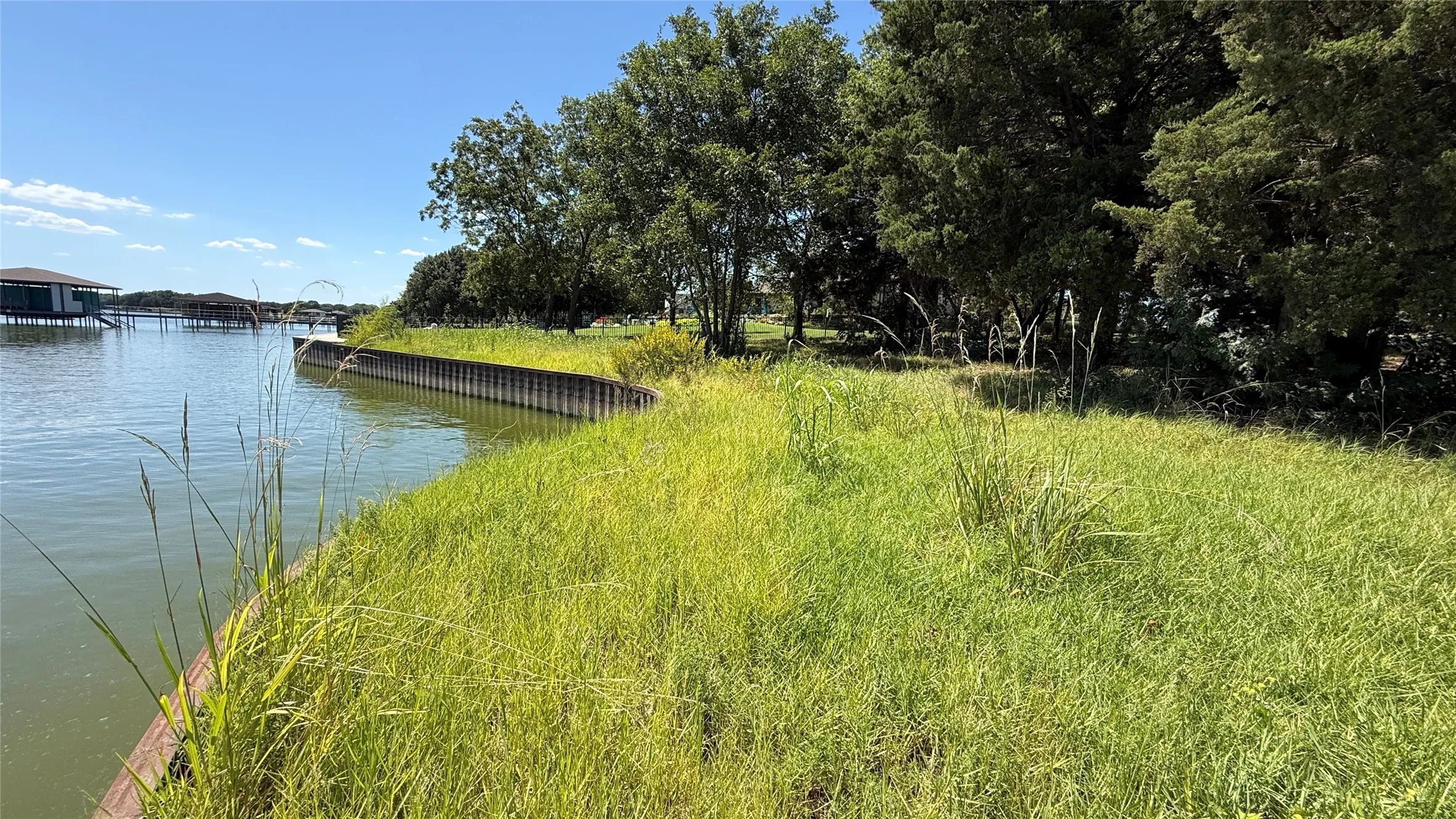 Grassy shoreline and steel retaining wall complement the peaceful setting of this potential Richland Chambers Lake retirement homesite.