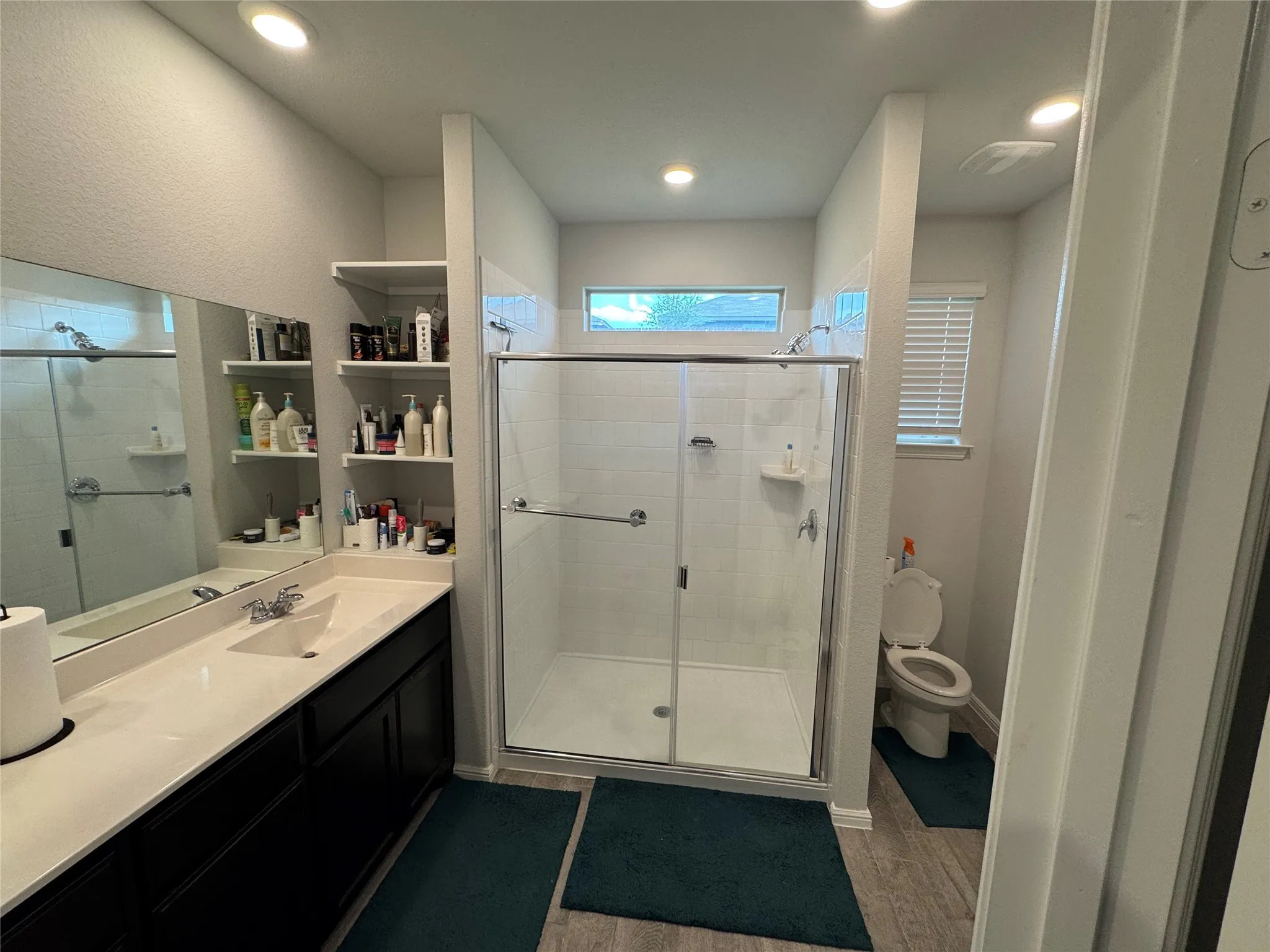 Full bathroom with a stall shower, wood finished floors, vanity, and recessed lighting