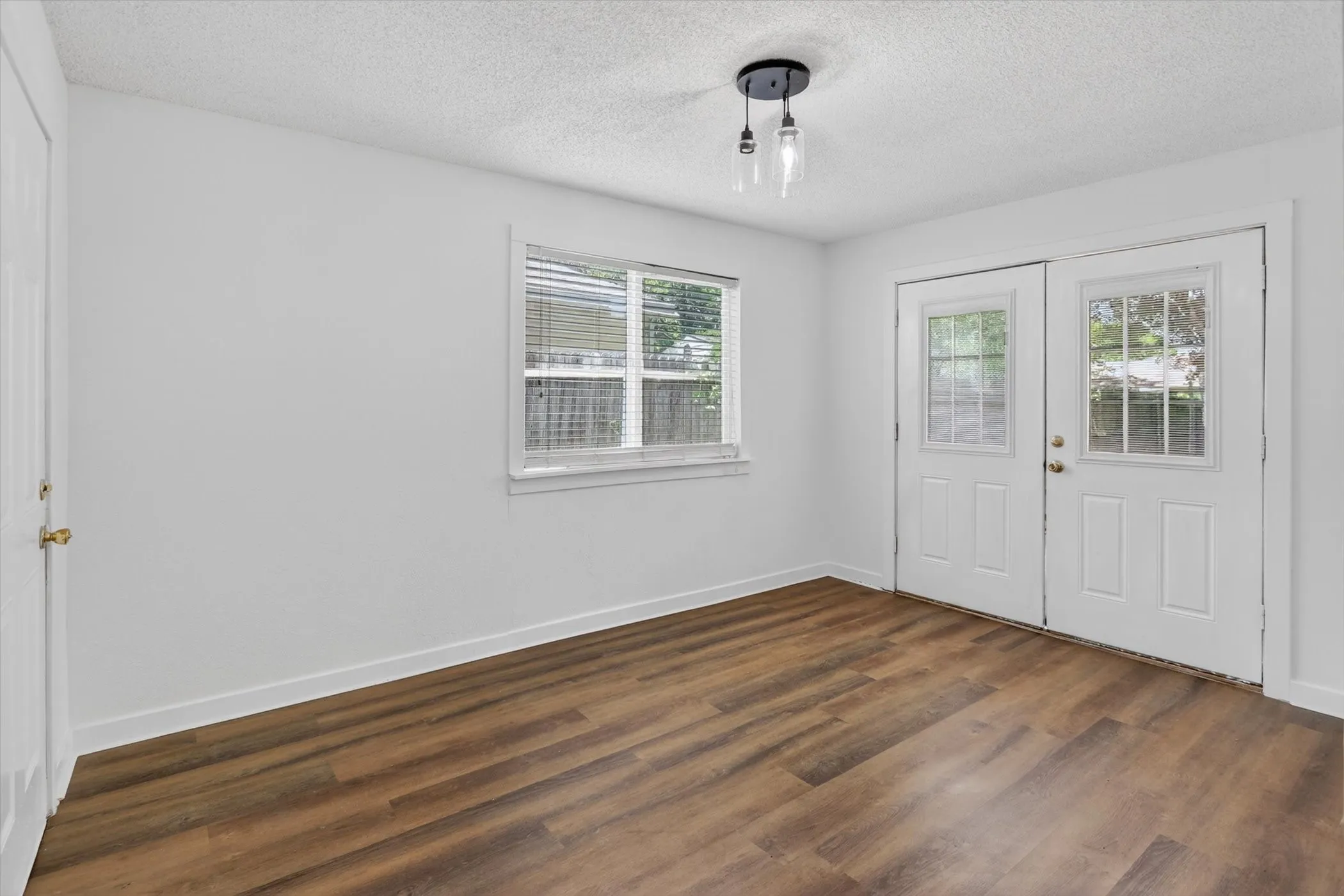 Wood-finish flooring throughout, complemented by white walls and trim