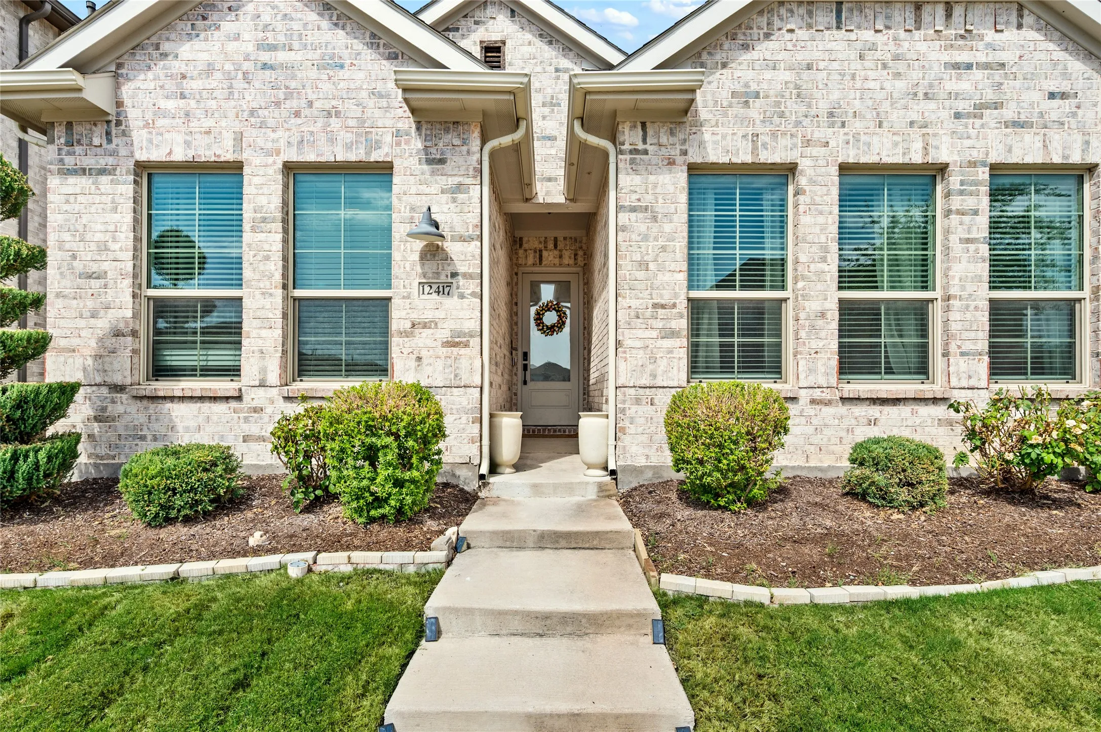 Beautifully landscaped flowerbed. Bright windows at the front of the home.