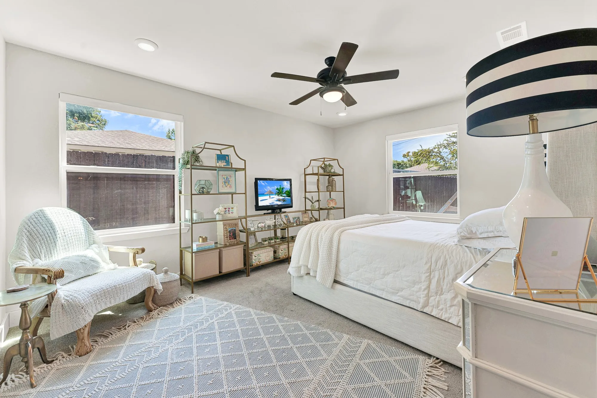 Recessed lighting, ceiling fan, and light gray carpet create a bright and comfortable atmosphere