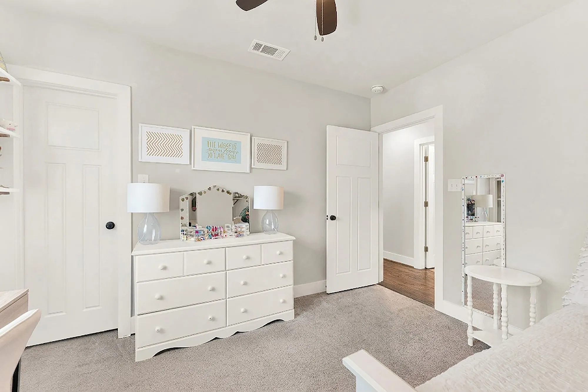 Plush carpeting, ceiling fan, white paneled doors, built-in shelving, and light gray wall paint