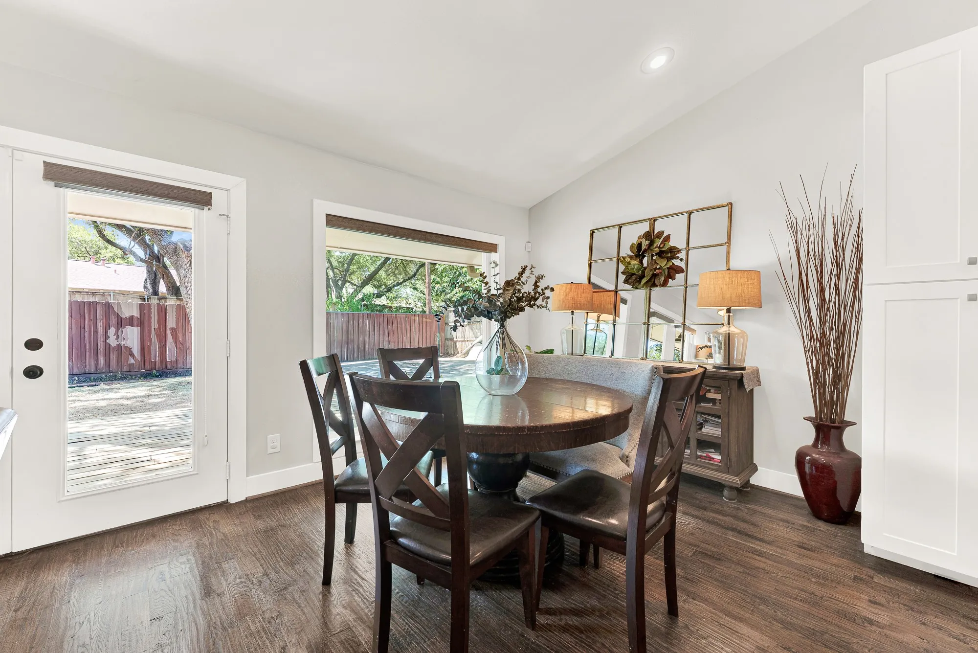 Wood-finish flooring, white paneled cabinetry, light-toned walls, and a glass-paned door