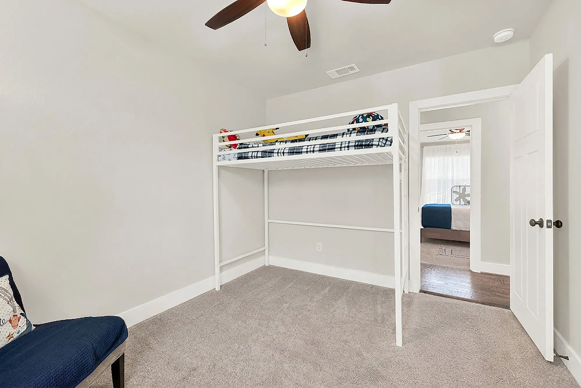 Plush gray carpeting, white trim, and a ceiling fan with integrated lighting