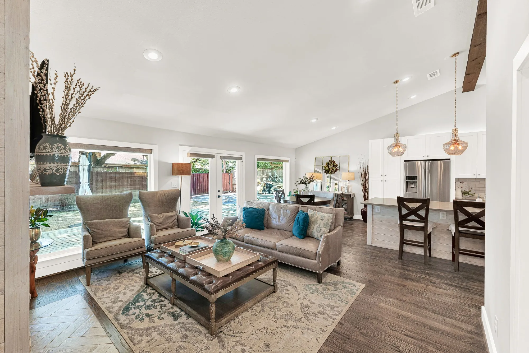Vaulted ceilings with exposed beams, wood-finish flooring, recessed lighting, and expansive windows
