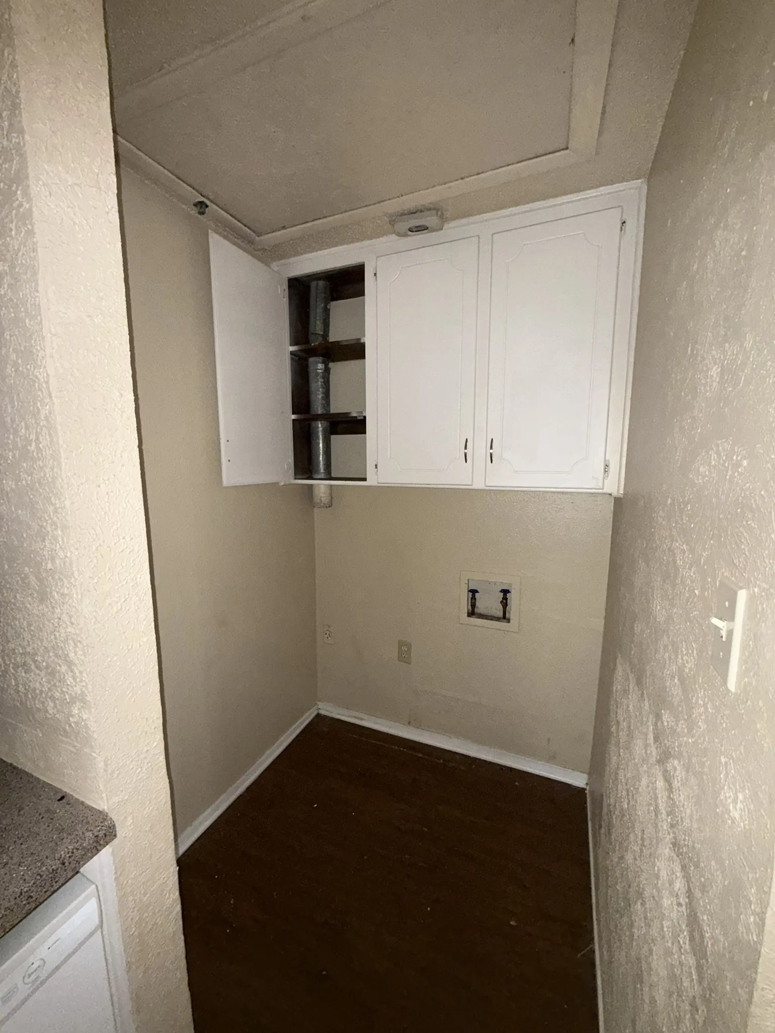 White upper cabinetry with one open door revealing interior shelving