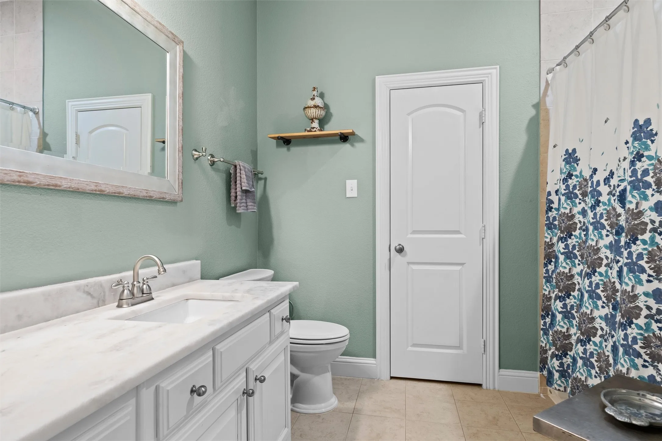 White vanity with brushed nickel hardware, integrated rectangular sink, and stone countertop
