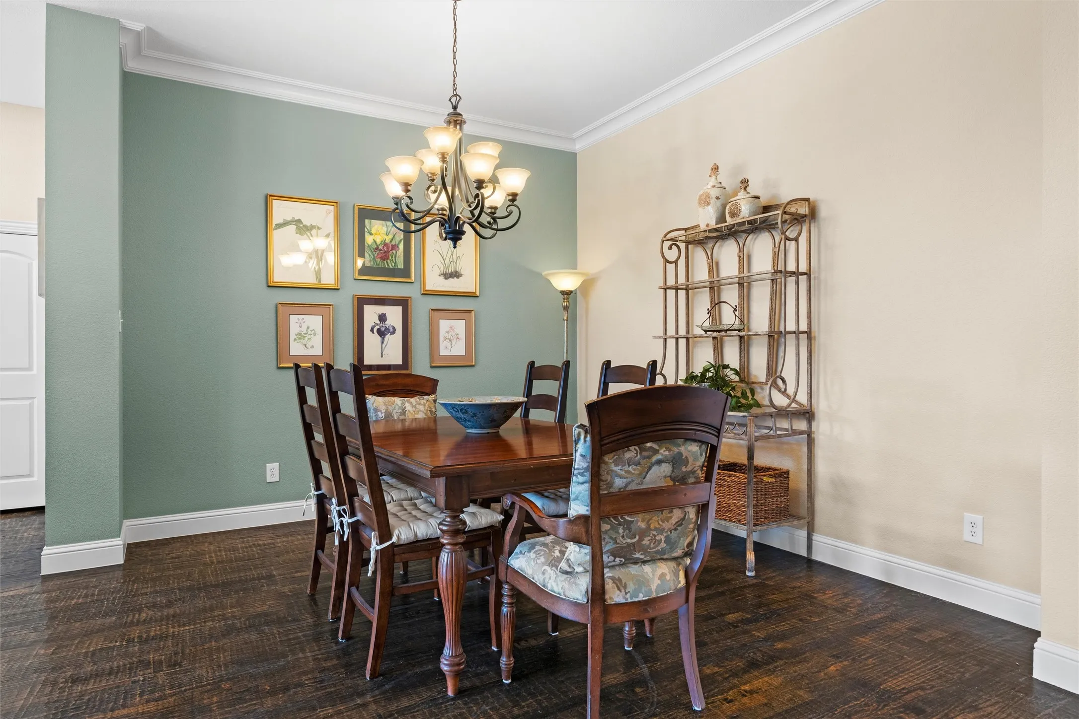 Wood-finish flooring, crown molding, and a decorative chandelier