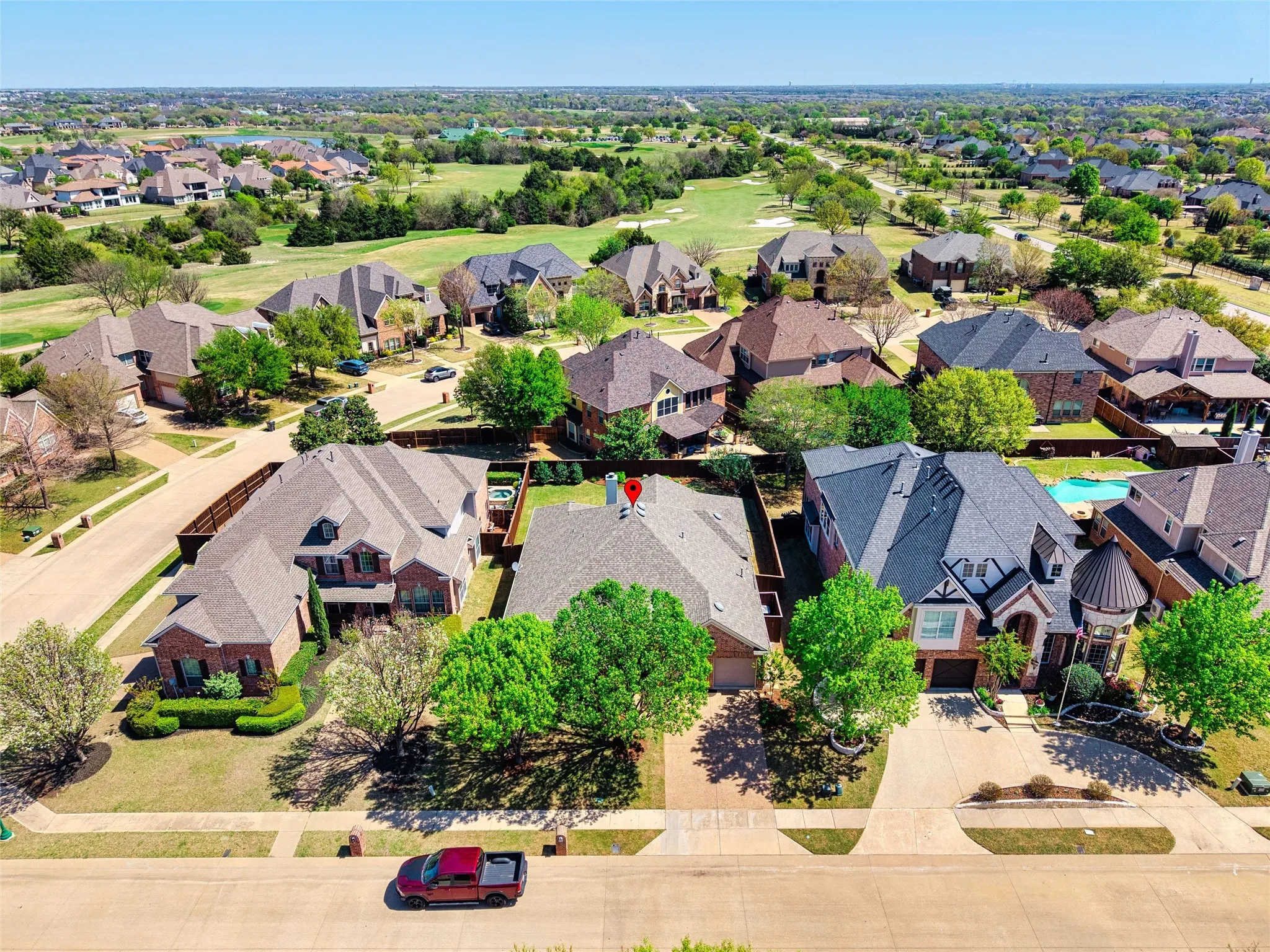 Neighborhood setting with mature trees and a golf course backdrop