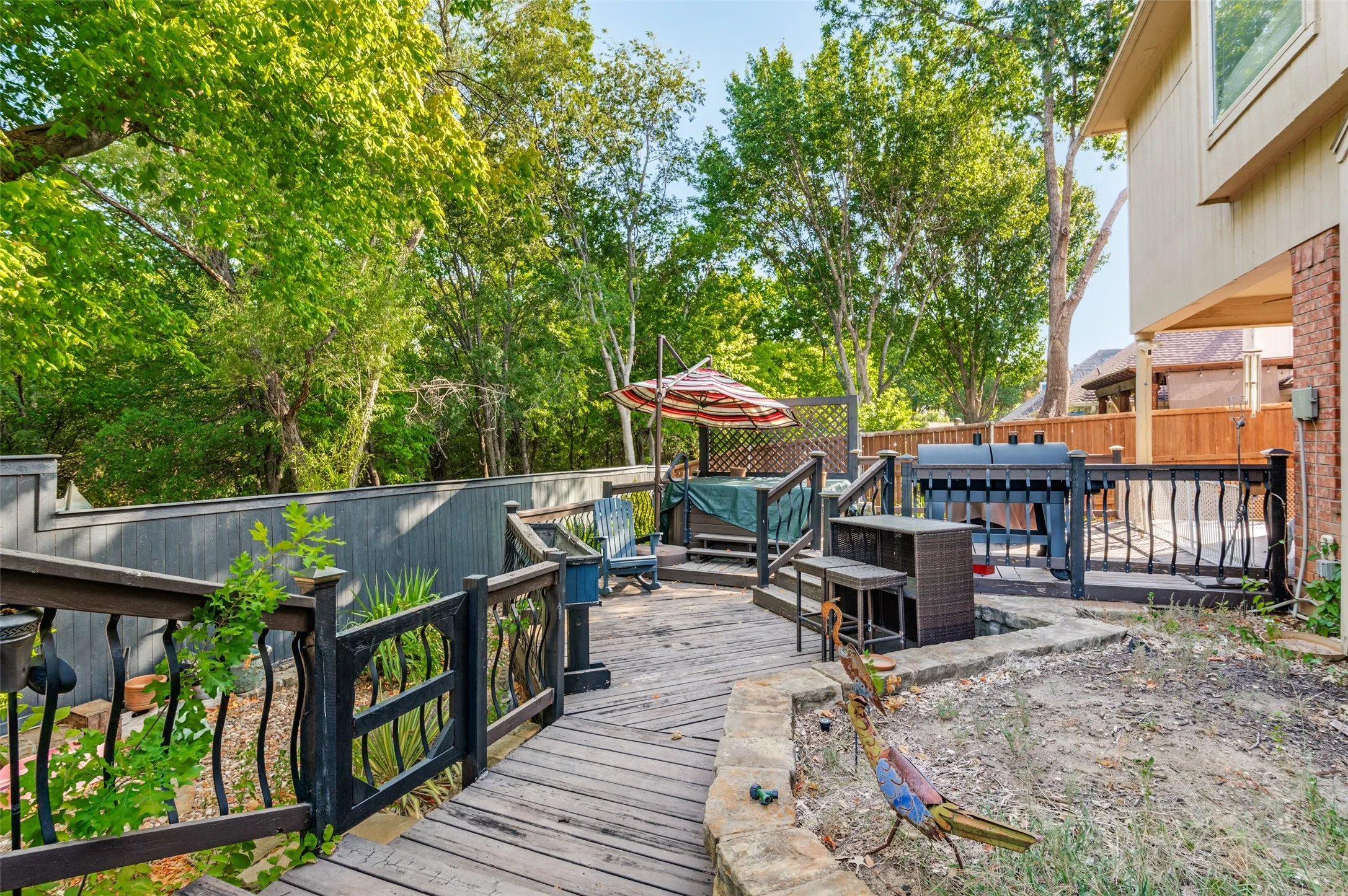 Multi-level wood deck with black wrought iron railings