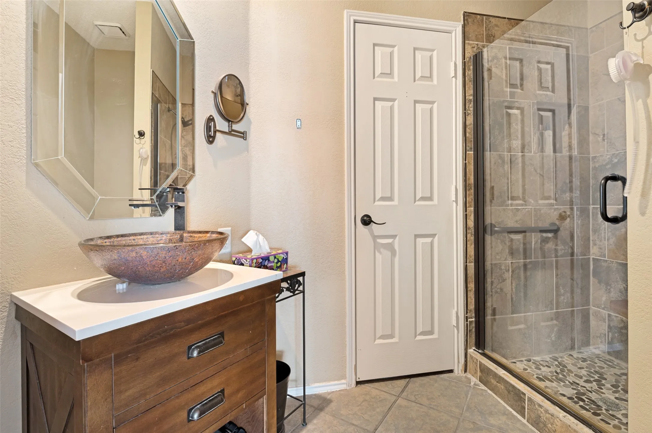 Downstairs Full Bath off the Bonus Room with Wood-finish vanity with a vessel sink, a shower enclosure with a glass door, and tiled flooring