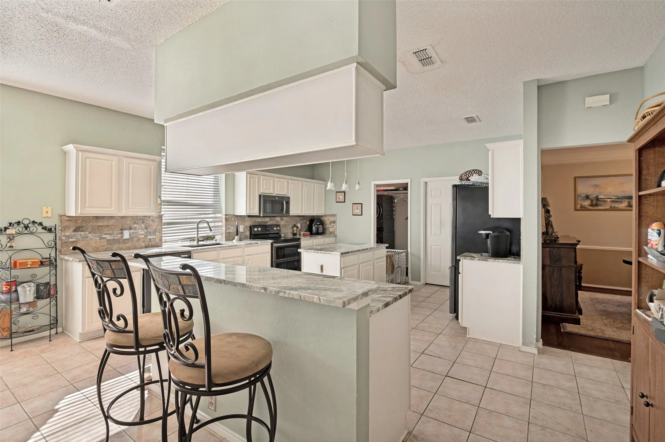 Large Kitchen with Granite Counters and Bar Seating.  Kitchen also has an Island.