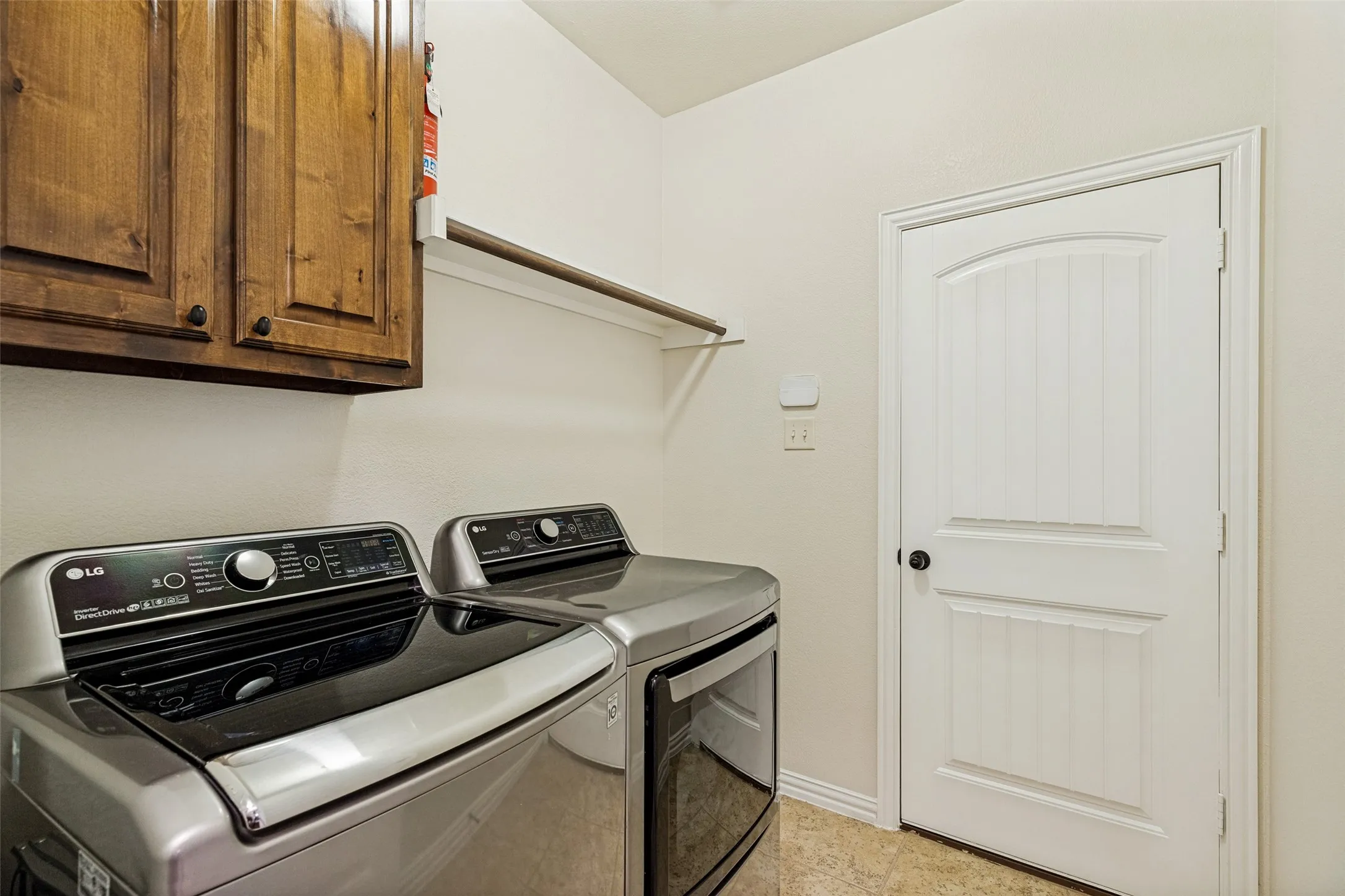 Built-in wood cabinetry, white interior door with arched detail, and a wall-mounted shelving unit