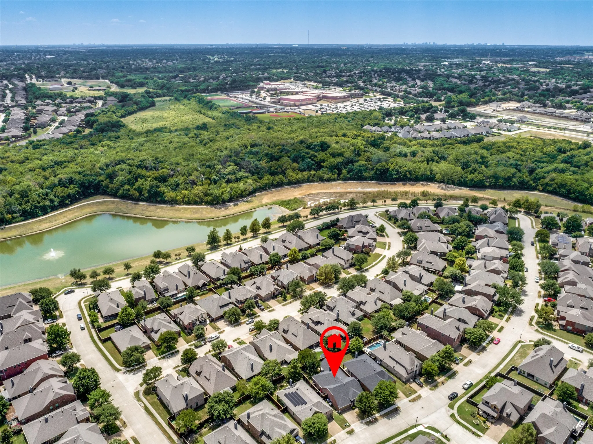 Residential neighborhood with mature trees, a curving street, and a nearby body of water