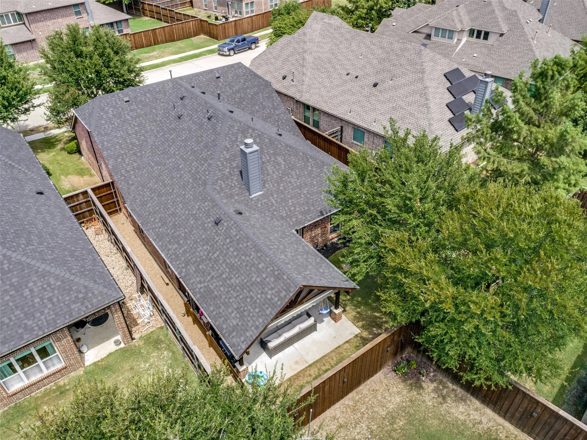 Shingle roof, brick exterior, fenced backyard, covered patio, and chimney