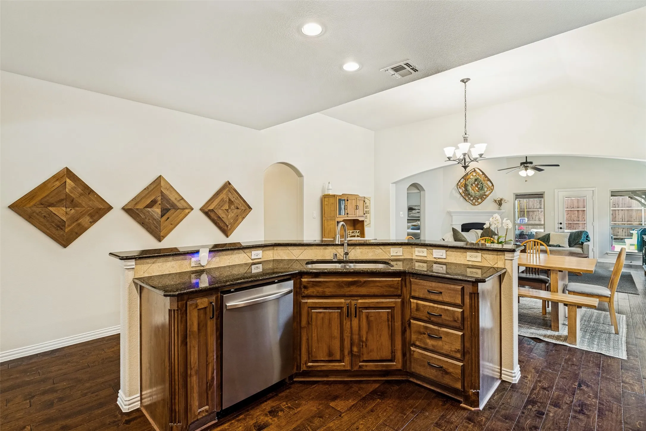 Vaulted ceiling with crown molding, wood-finish flooring, ceiling fan with light fixture, and a large window with ample natural light