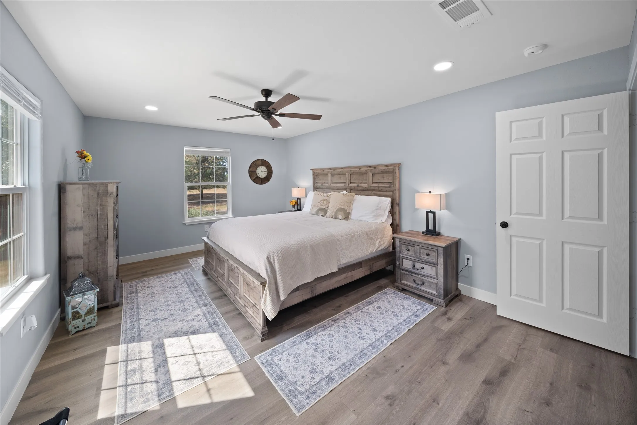 Light-toned wood-finish flooring complements the neutral wall color