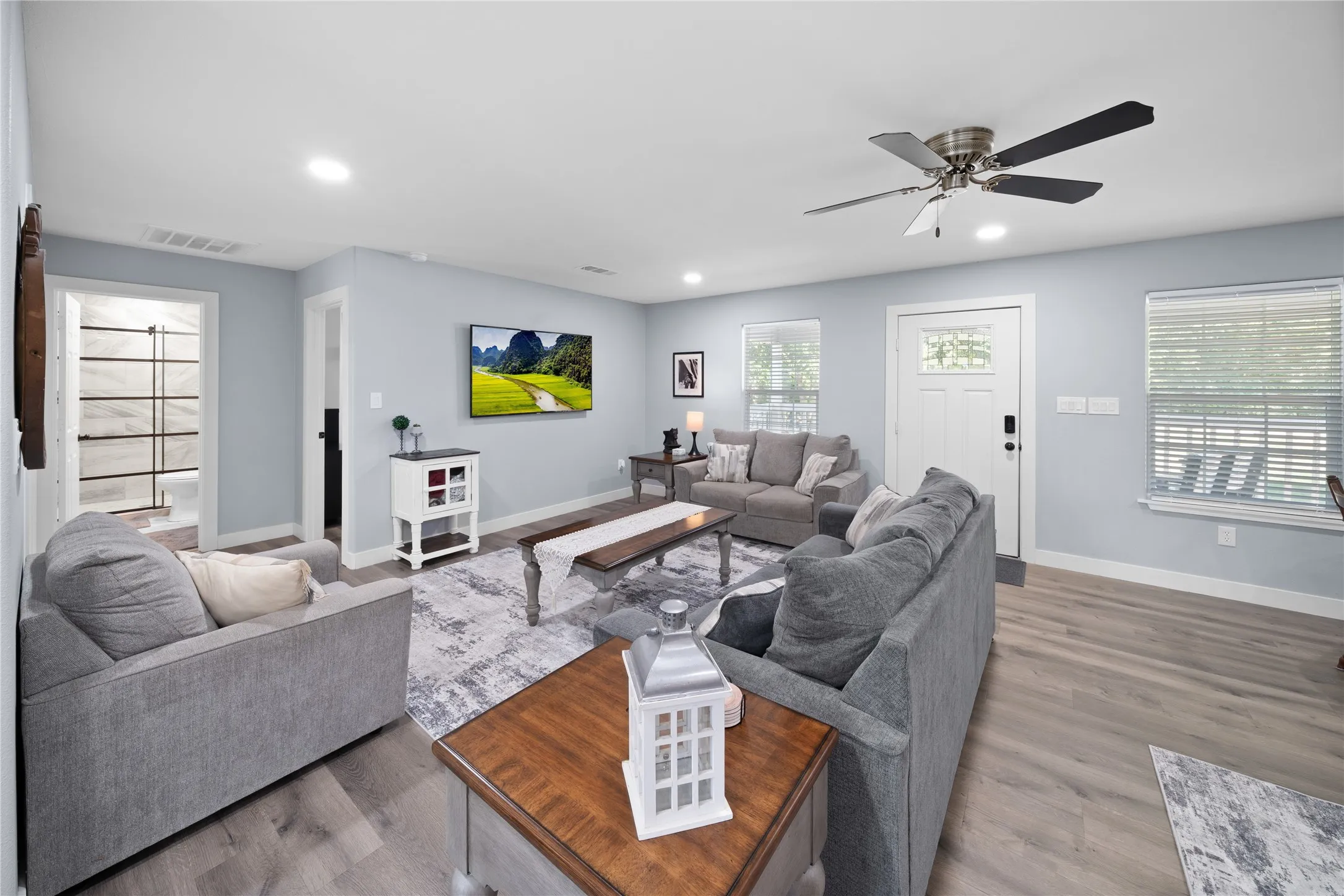 Spacious living area featuring wood-finish flooring, recessed lighting, and a ceiling fan