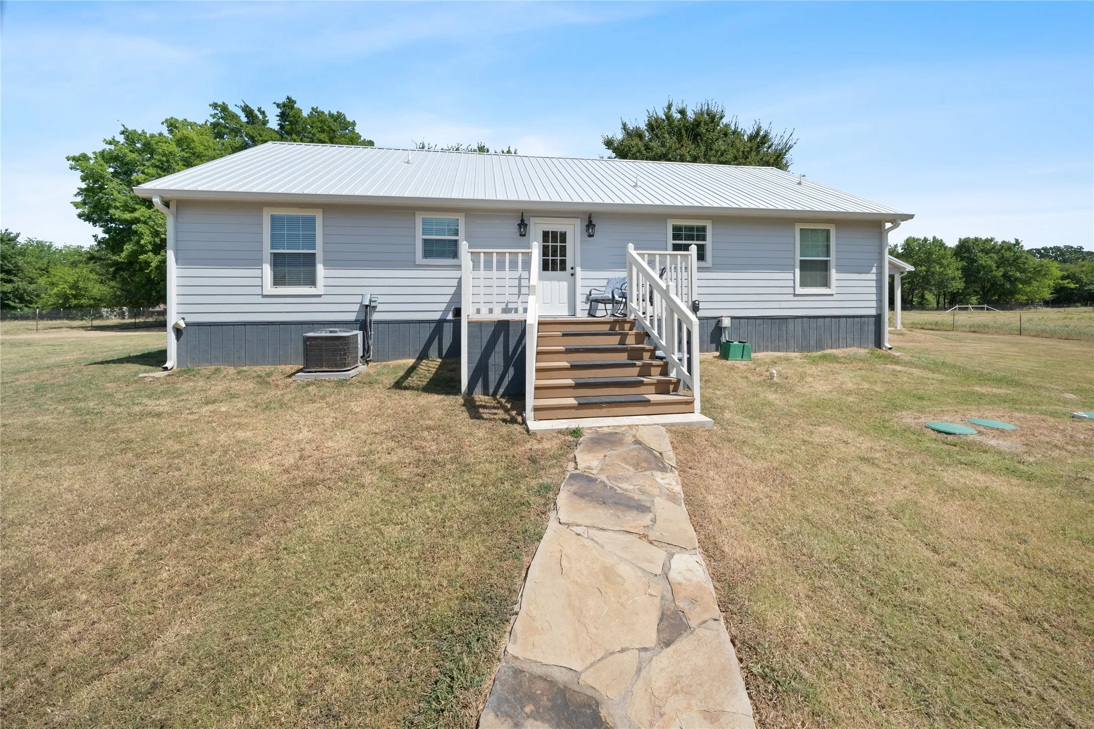 Light blue siding exterior with a metal roof