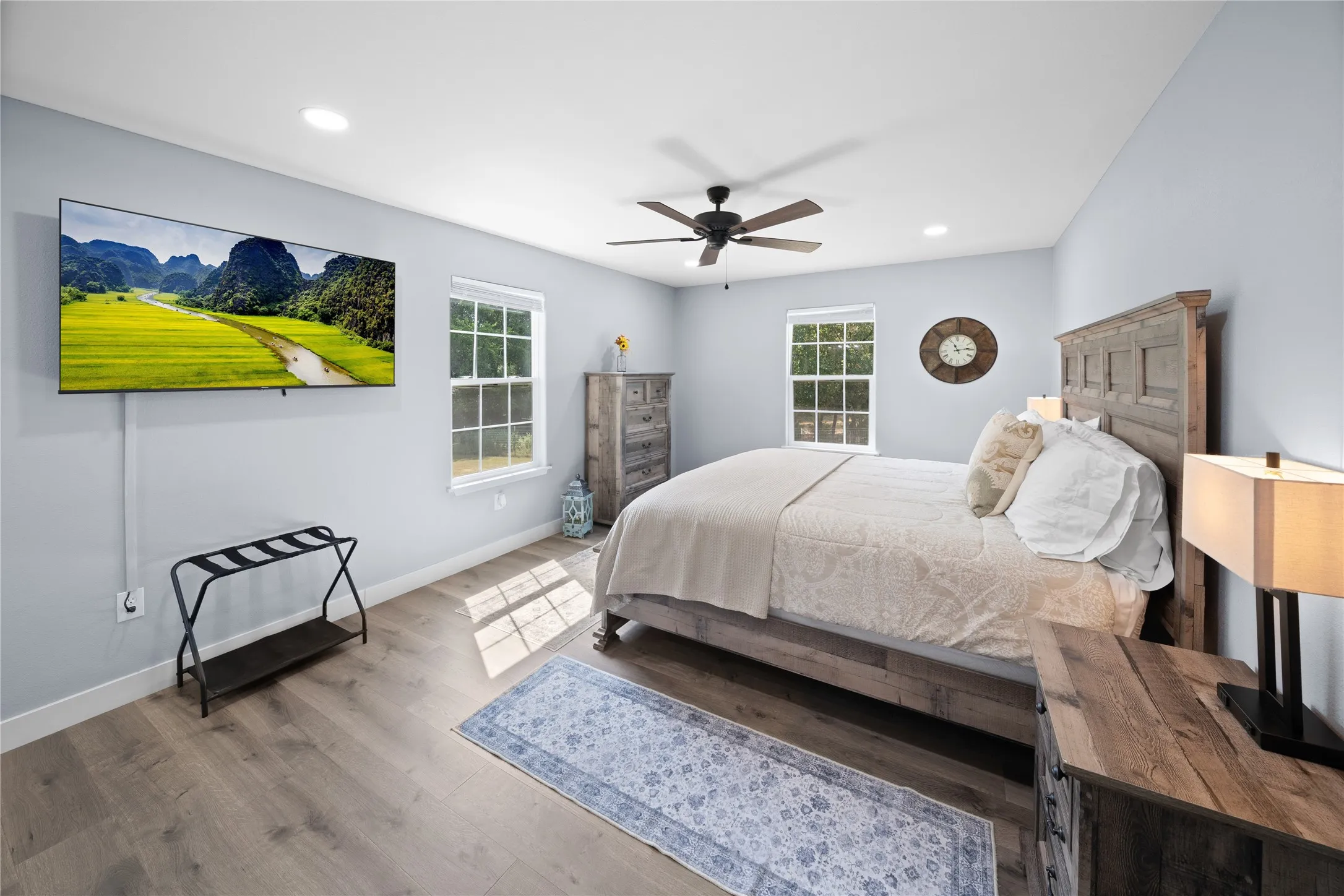 Recessed lighting, wood-finish flooring, multiple windows, and a ceiling fan with integrated lighting