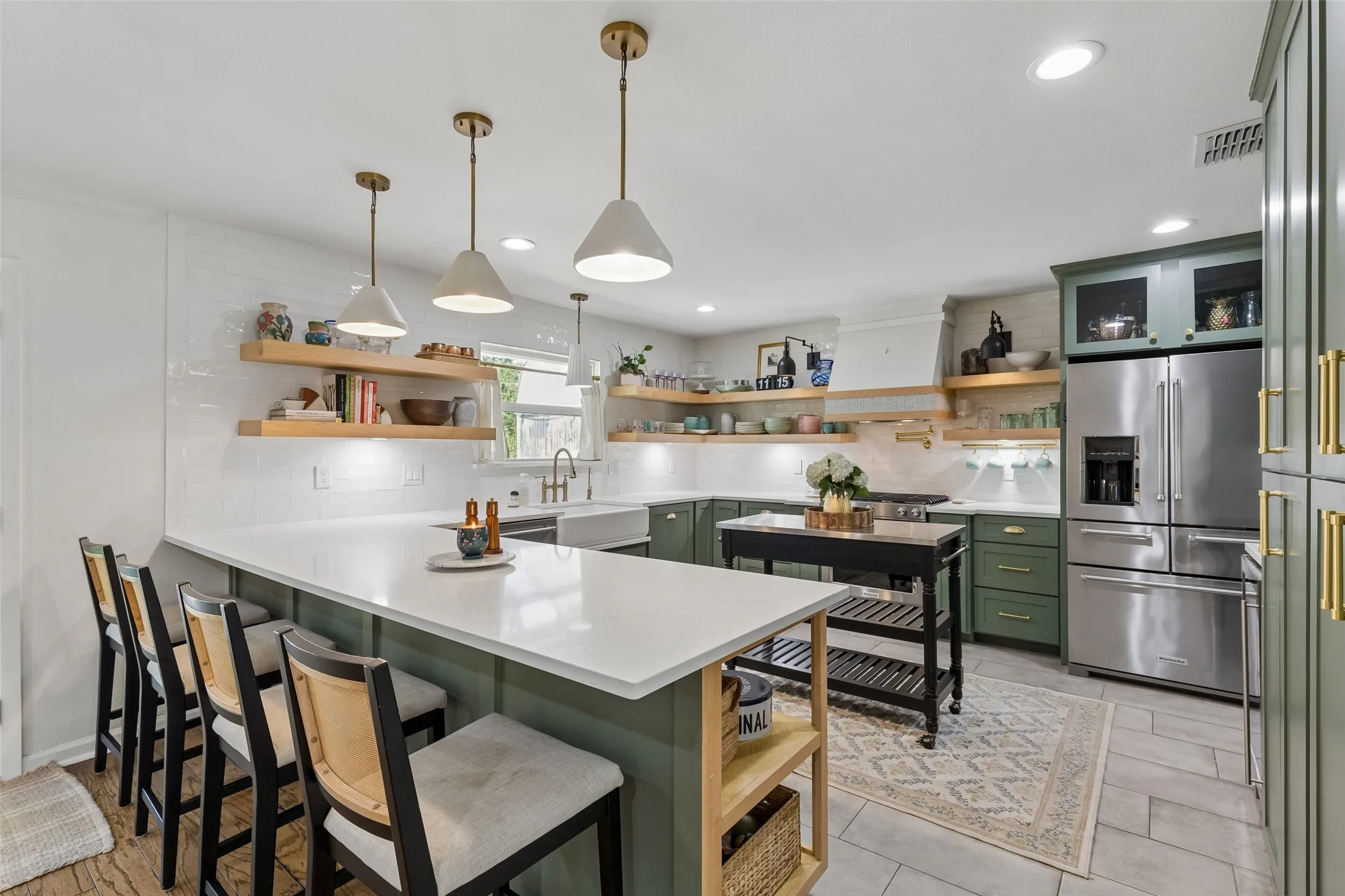 Gorgeous rich sage green kitchen with eat in kitchen seating.