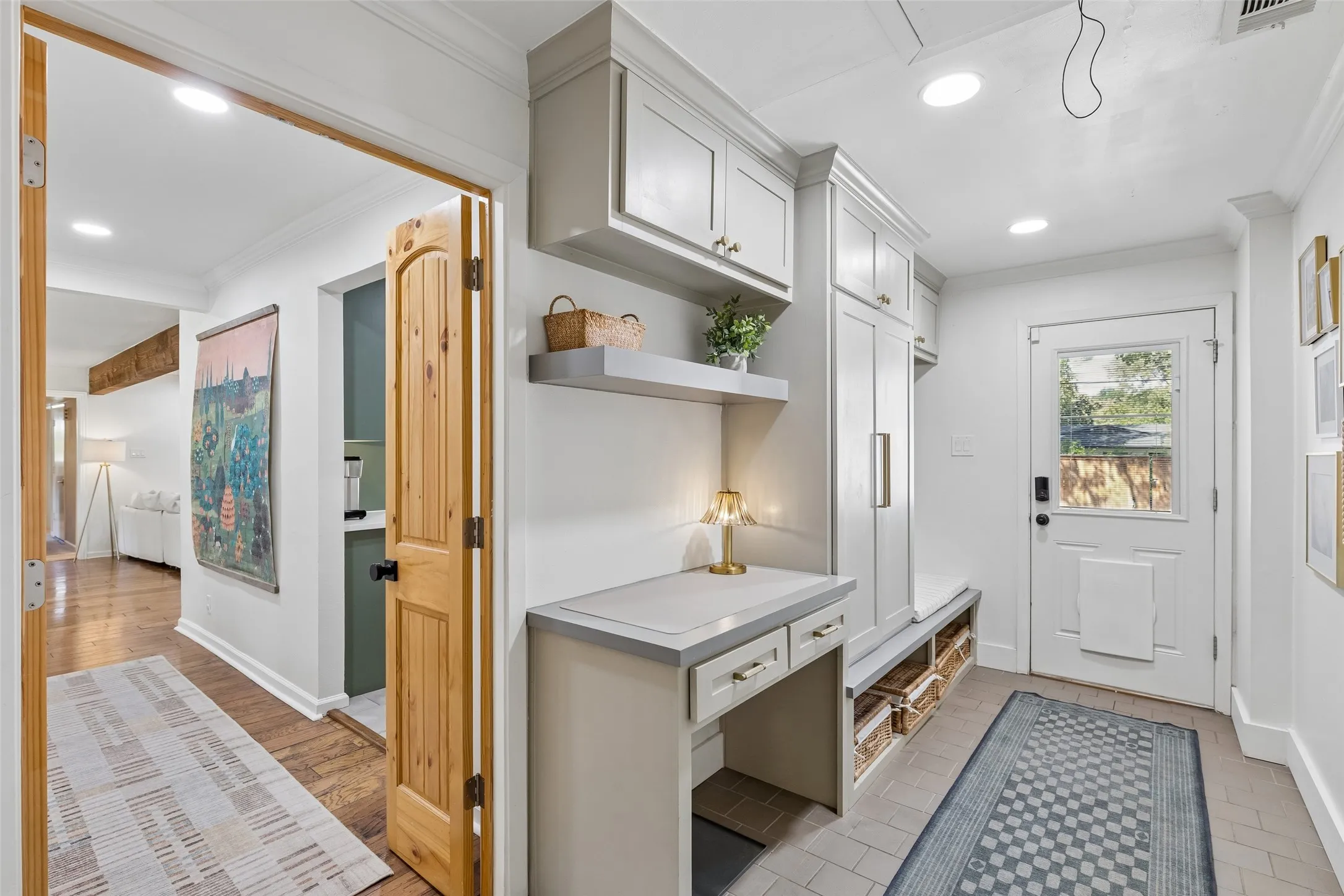 Mud room with built in cabinets, desk and backyard access.