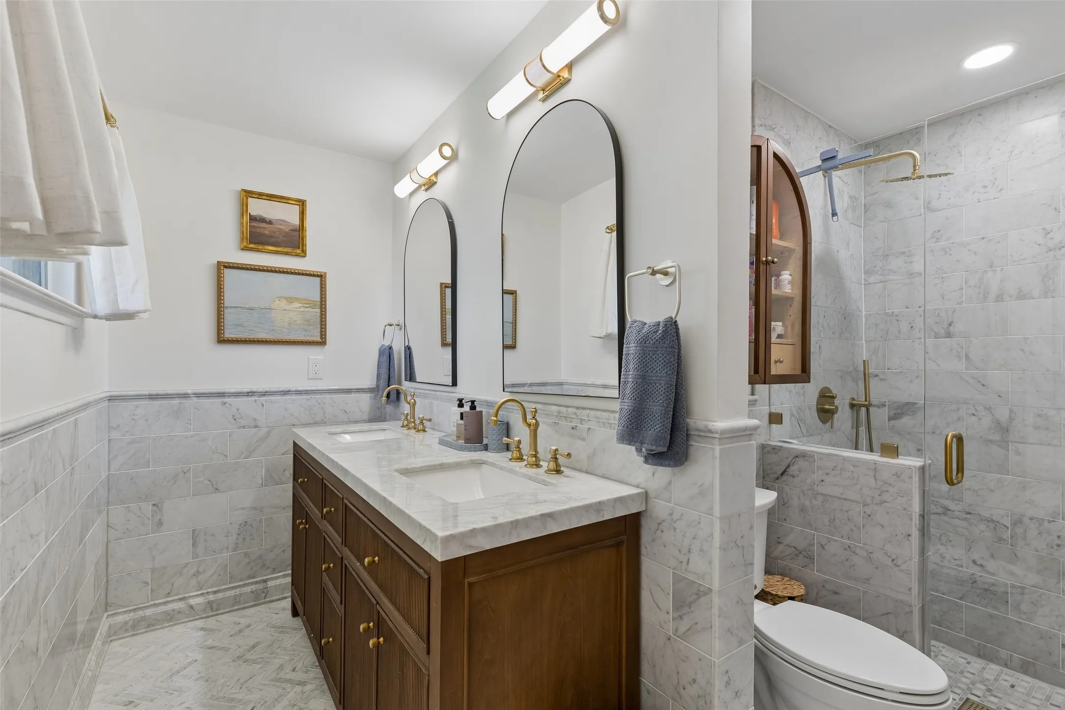 Dual marble vanity sink, marbled wainscot walls and floors