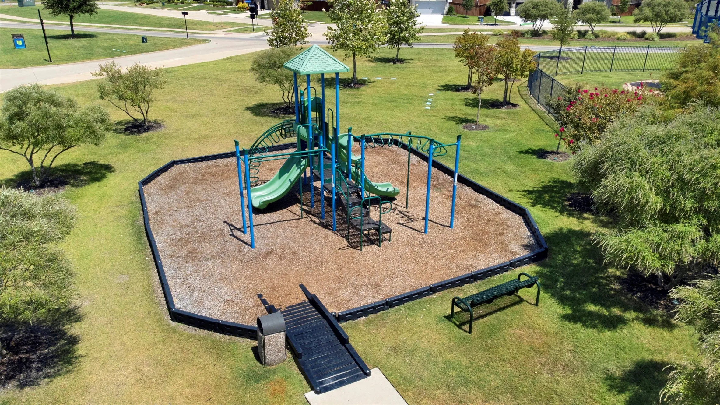 Community park featuring a play structure, green spaces, and mature landscaping
