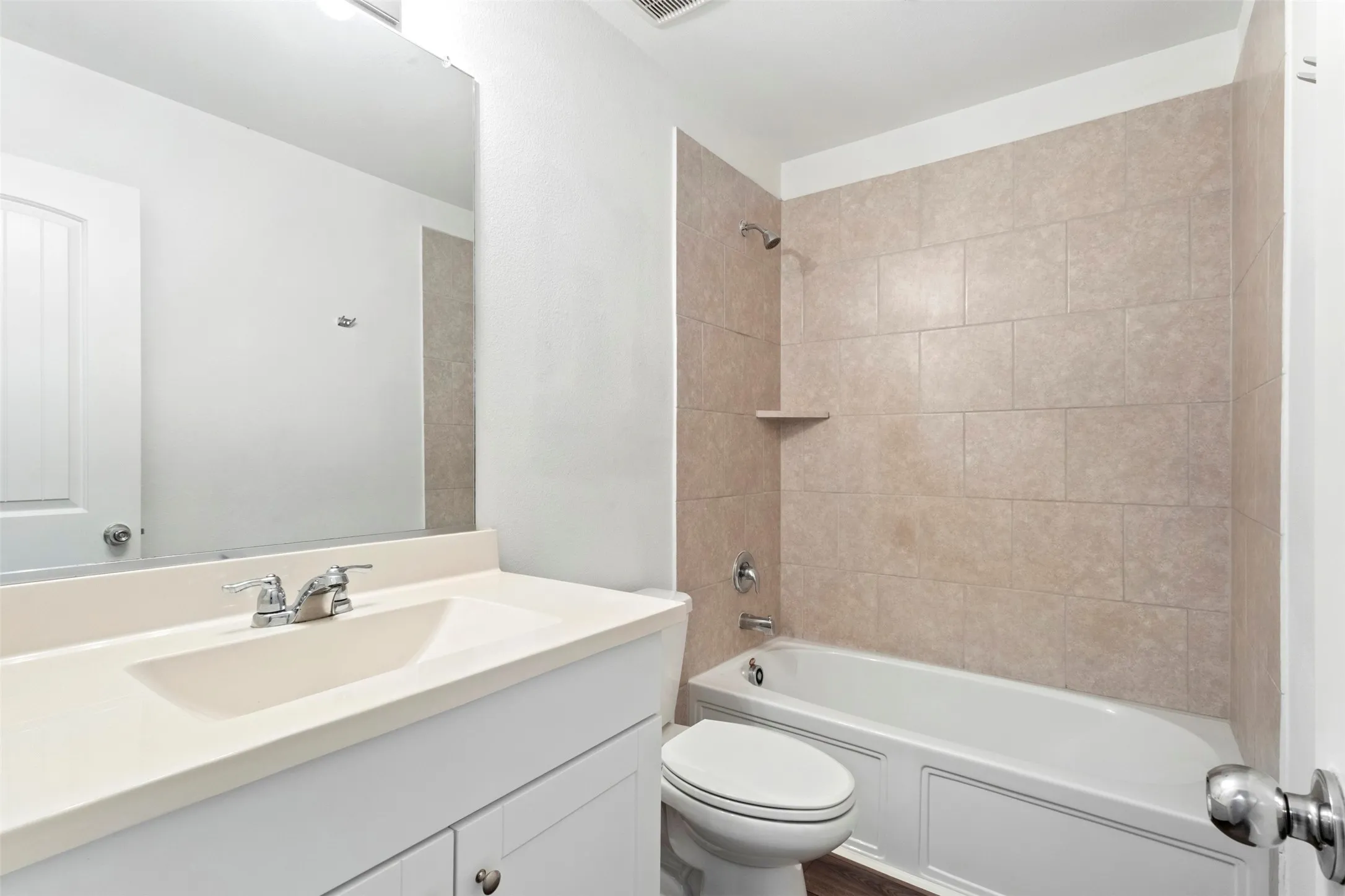 Bathroom featuring a vanity with a rectangular basin sink, chrome faucet, and white cabinetry