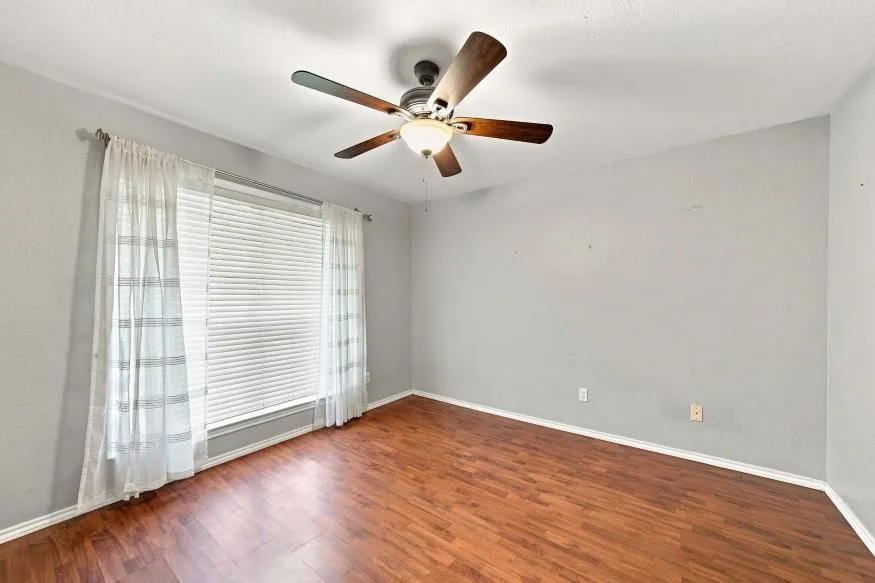 Recessed window with horizontal blinds, wood-finish flooring, ceiling-mounted fan, and textured ceiling