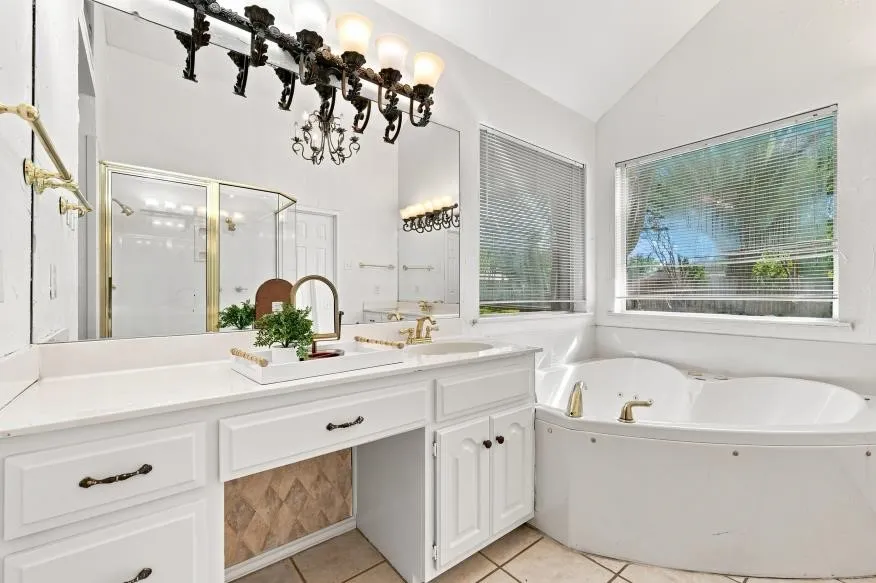 Dual vanity with white cabinetry, ample counter space, and a built-in makeup area