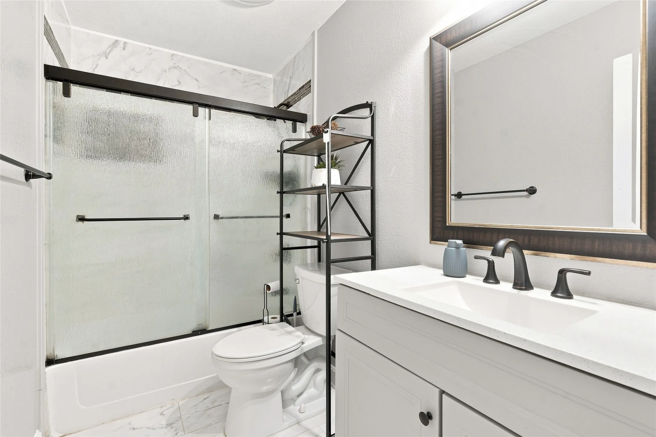 White vanity with an integrated sink and dark bronze faucet