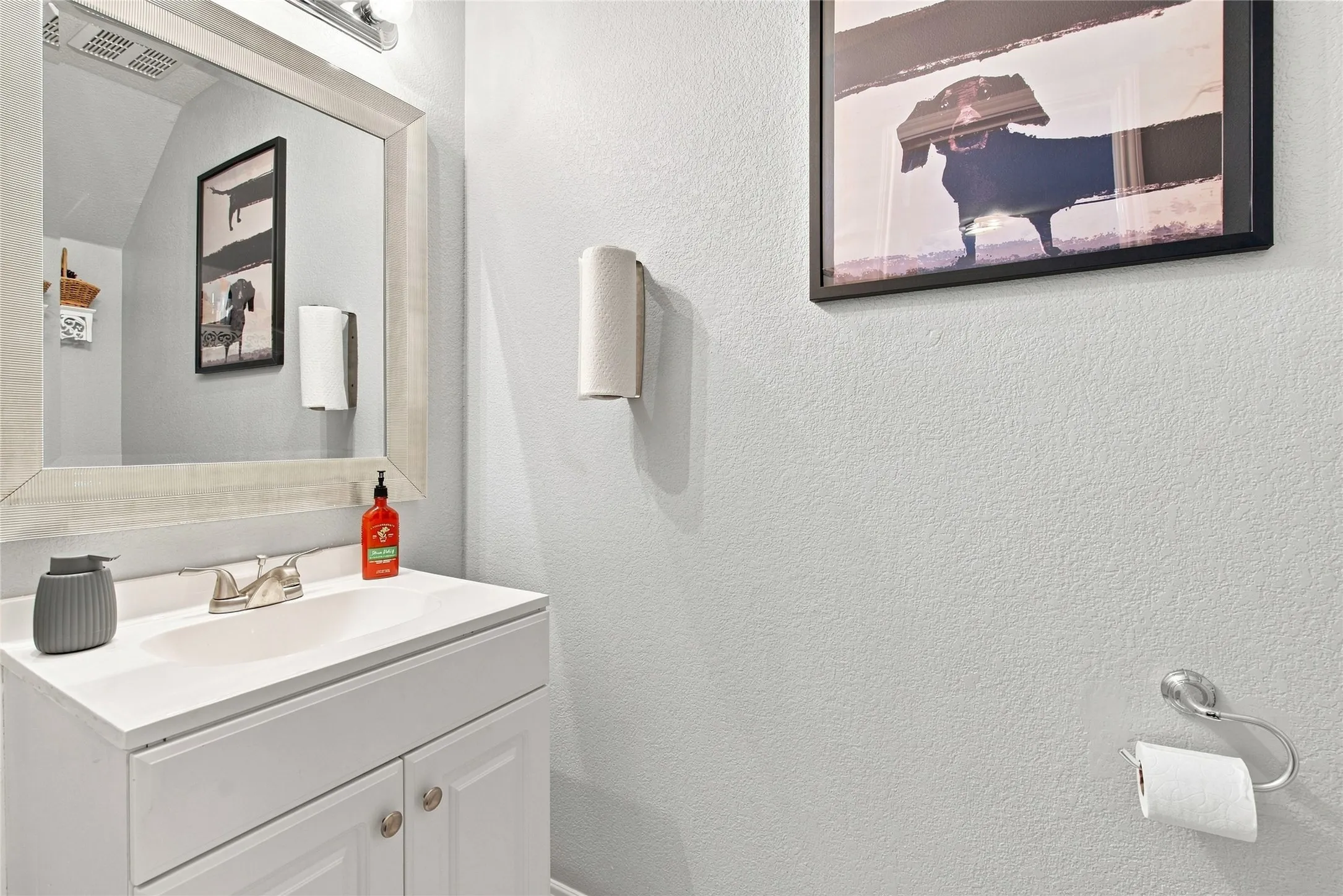 White vanity cabinet with brushed nickel hardware, integrated sink, and dual-handle faucet