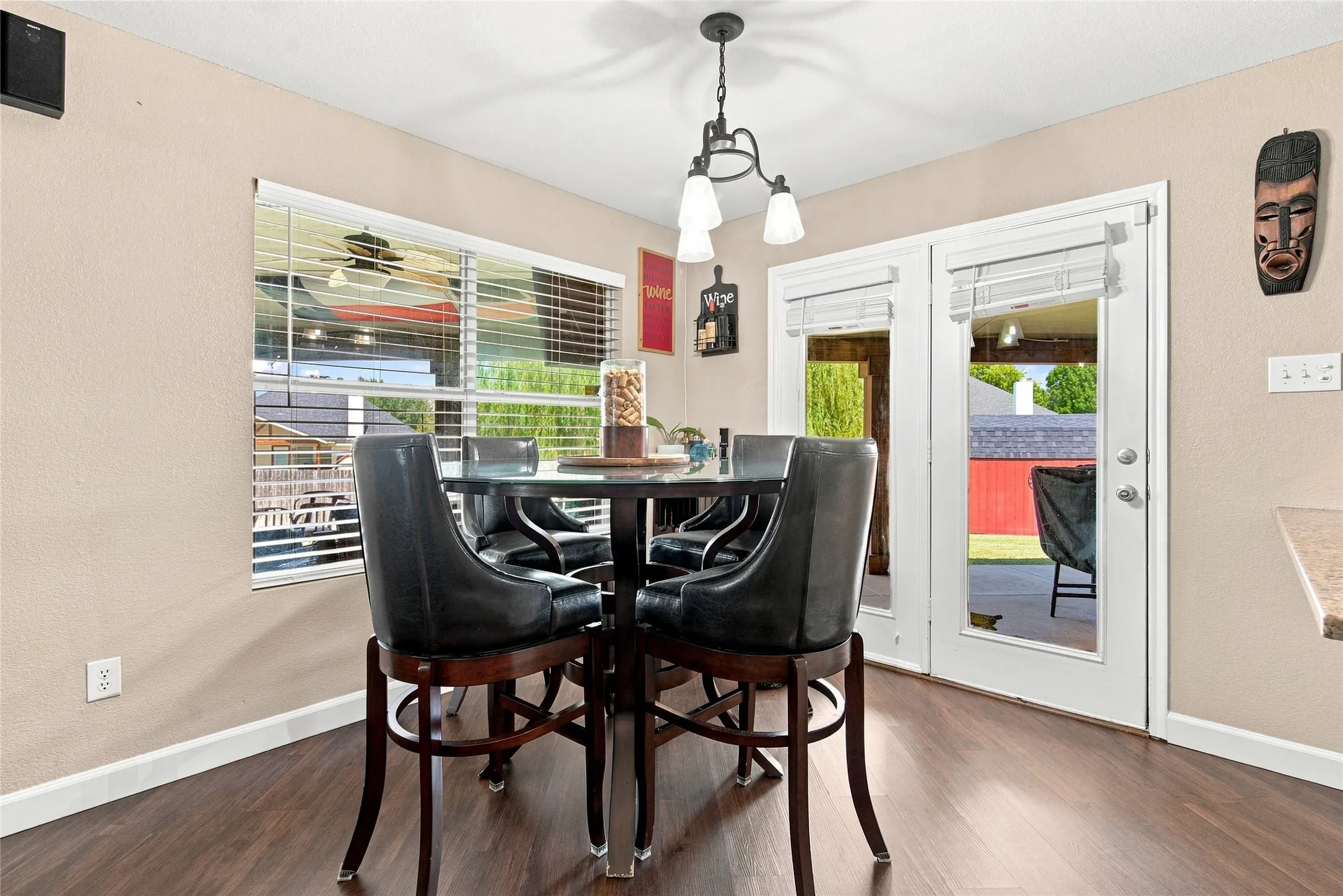 Wood-finish flooring, white trim, dual French doors, and a window with blinds