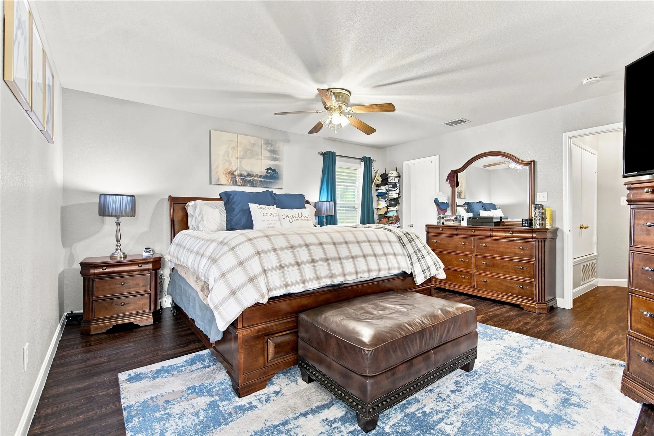 Wood-finish flooring, ceiling fan, white paneled doors, and light gray walls