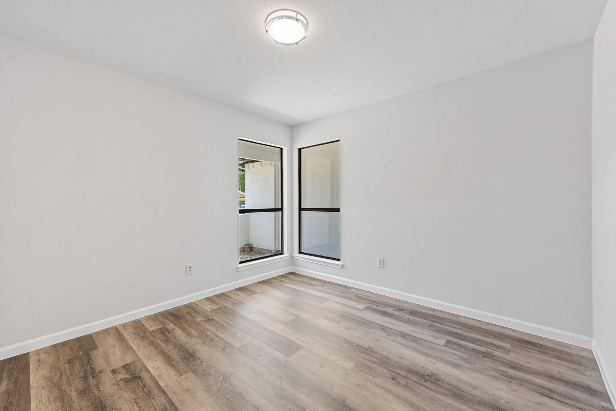 Wood-finish flooring, white walls, and a ceiling-mounted light fixture