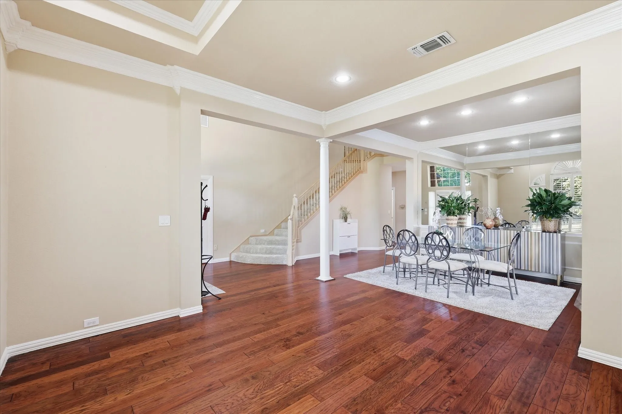 View of living area, dining room with decorative columns and trey ceilings