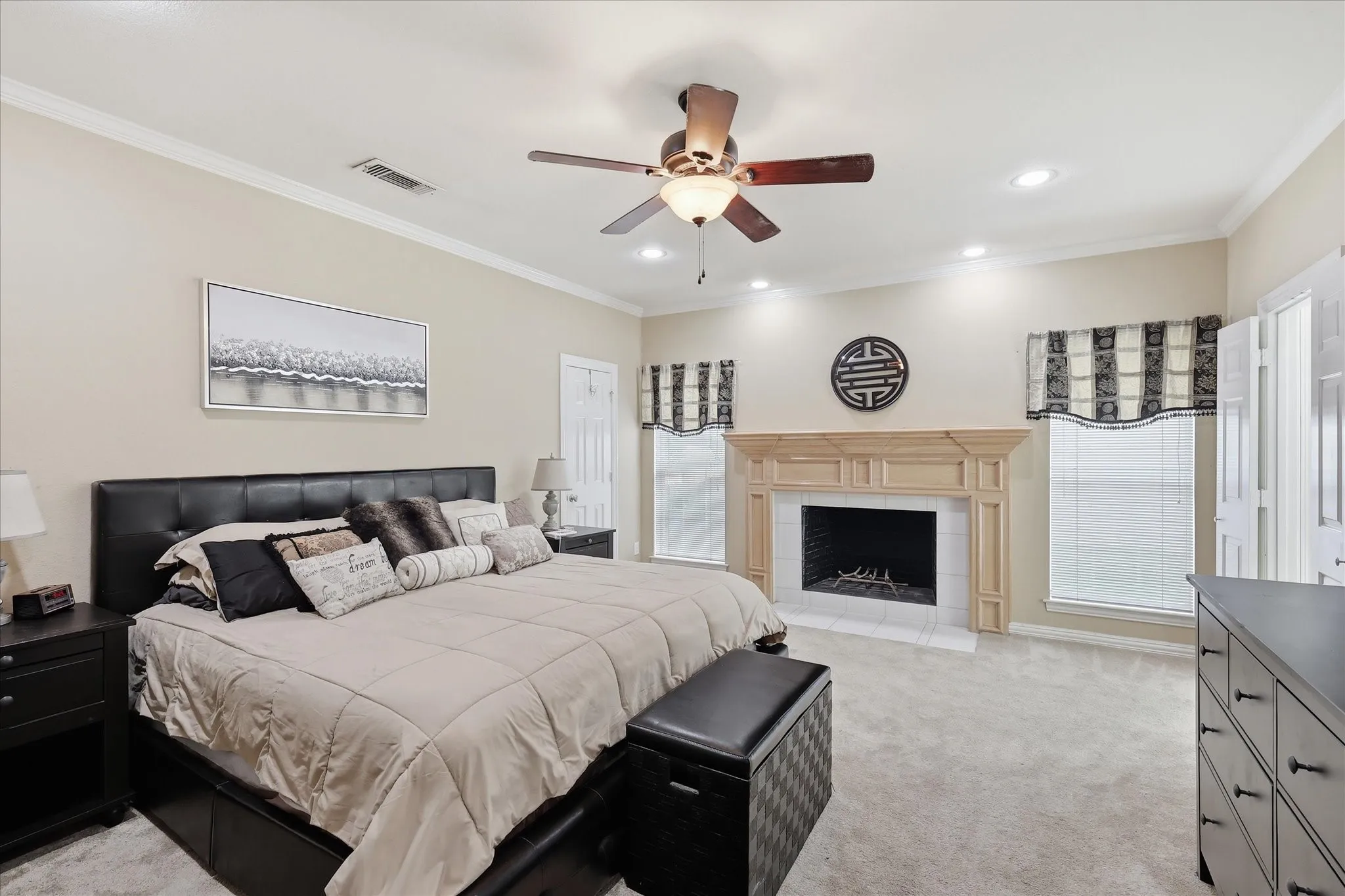 Oversized primary bedroom featuring fireplace, sitting area, his-her walk-in closets