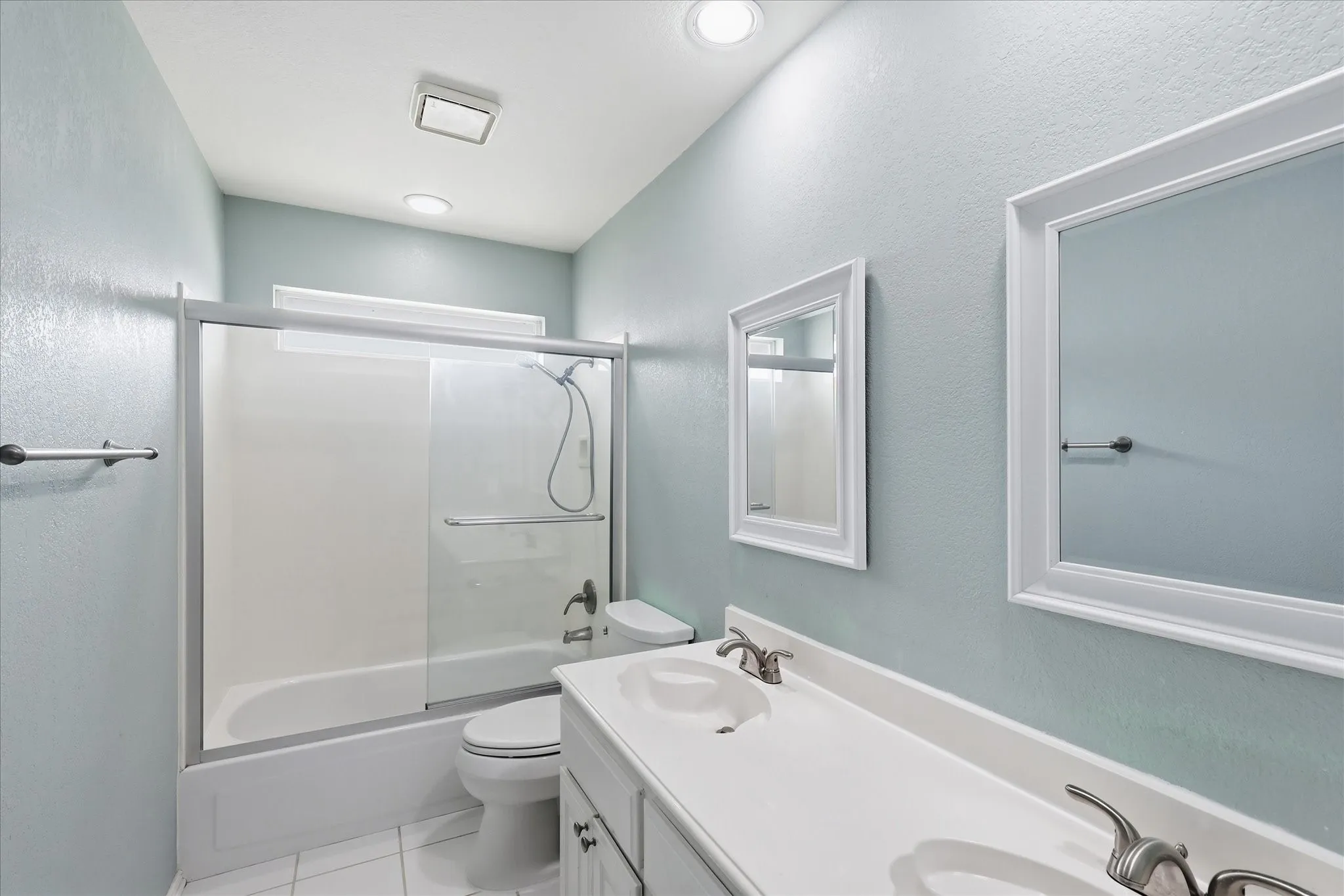 Secondary bathroom upstairs featuring dual sinks and mirrors with updated fixtures