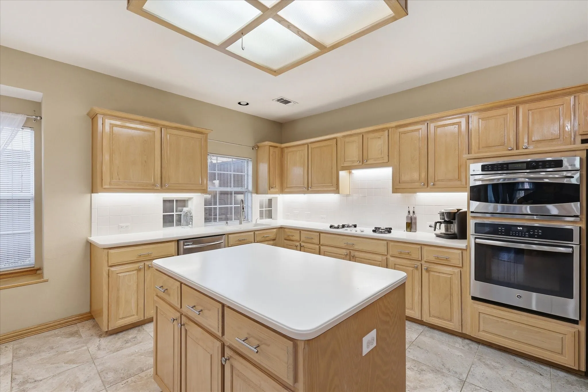 An abundance of cabinet space, stainless oven, convection microwave and a downdraft venting system for gas cooktop