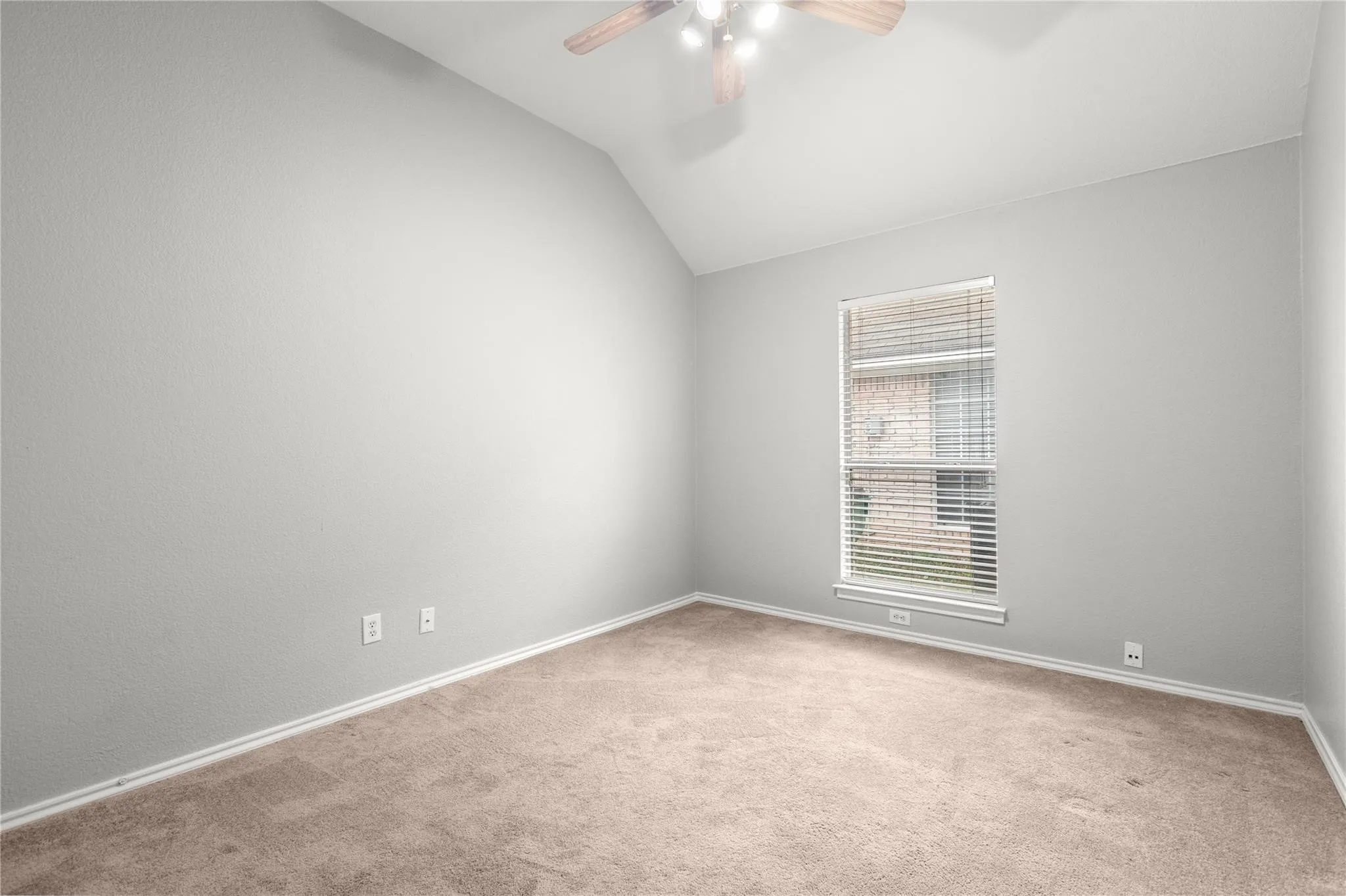Vaulted ceiling, carpeted flooring, window with blinds, and a ceiling fan with integrated lighting