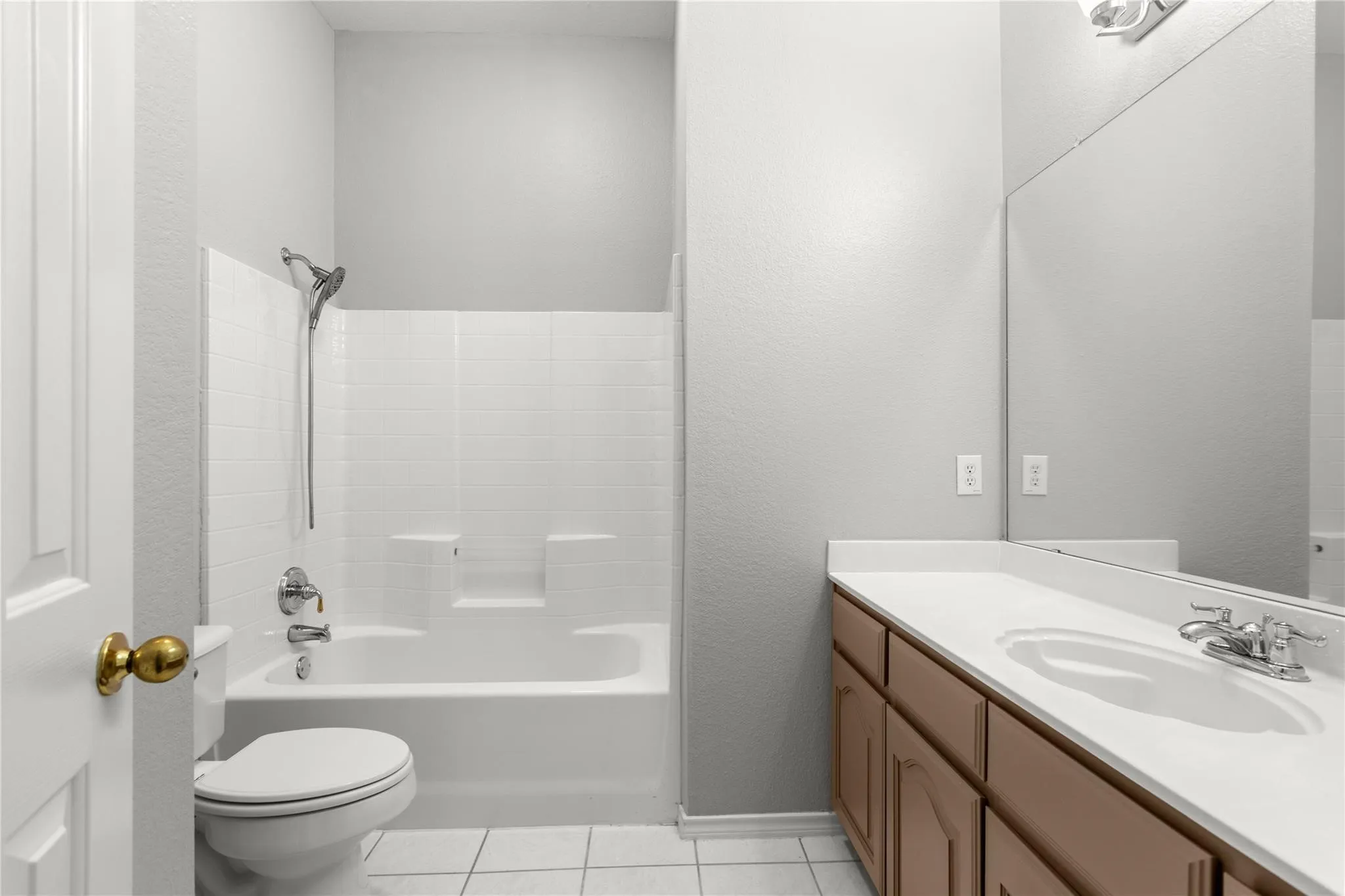 White tiled flooring with a full bathtub and shower combination